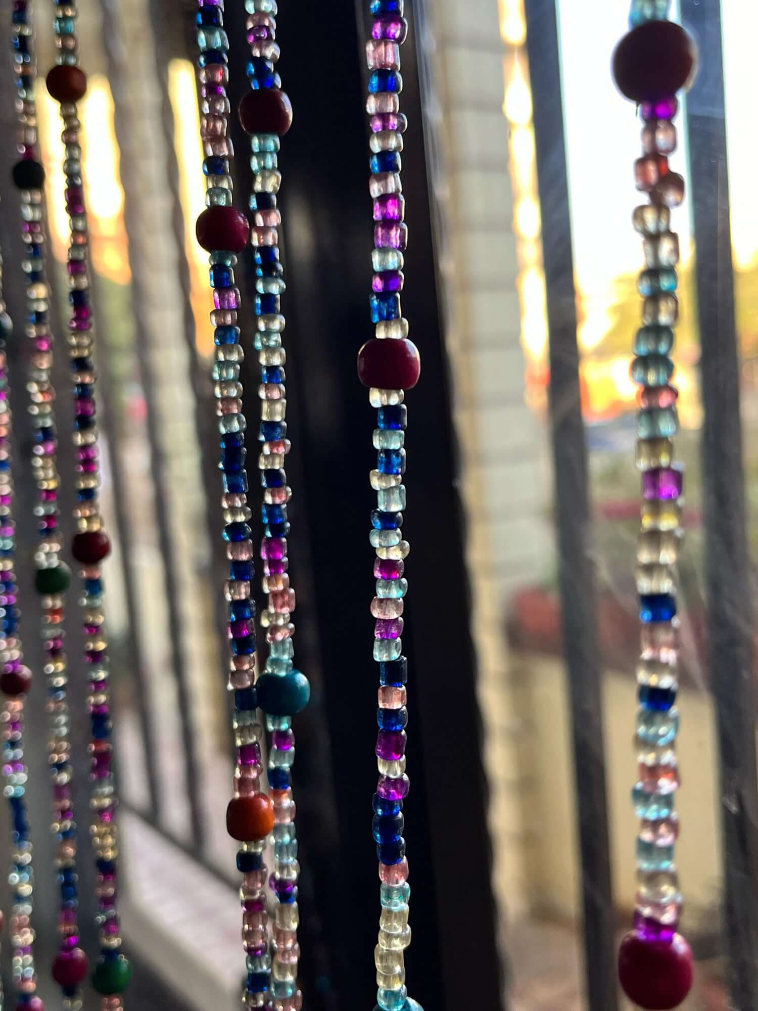 Handmade colorful glass bead strands with jingle bells—perfect for doorways or wall décor. Eco-friendly and crafted by women's artisans in India.