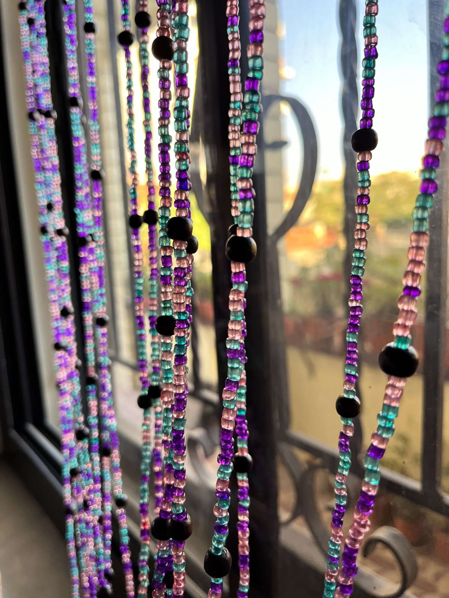 Handmade colorful glass bead strands with jingle bells—perfect for doorways or wall décor. Eco-friendly and crafted by women's artisans in India.