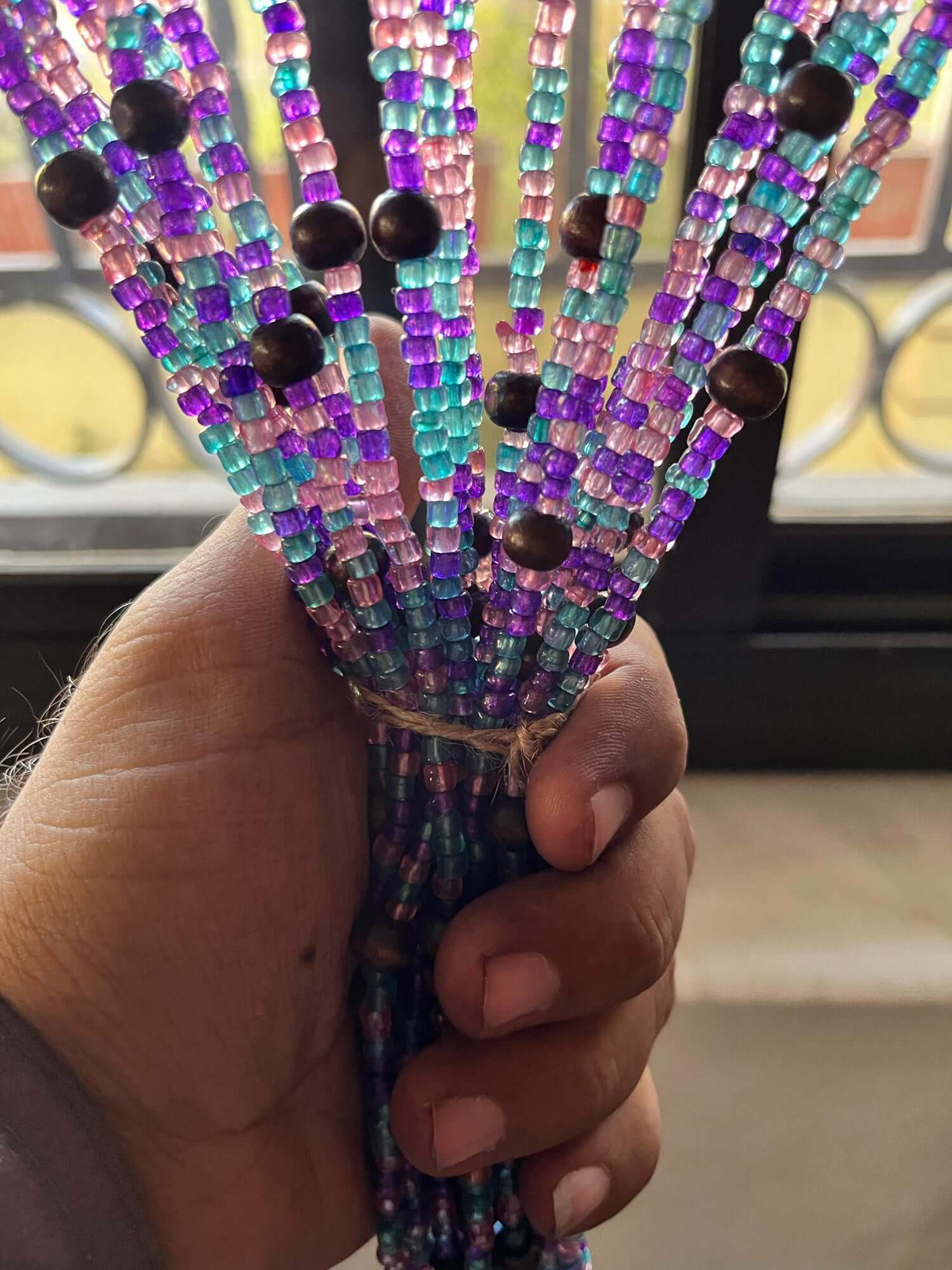 Handmade colorful glass bead strands with jingle bells—perfect for doorways or wall décor. Eco-friendly and crafted by women's artisans in India.