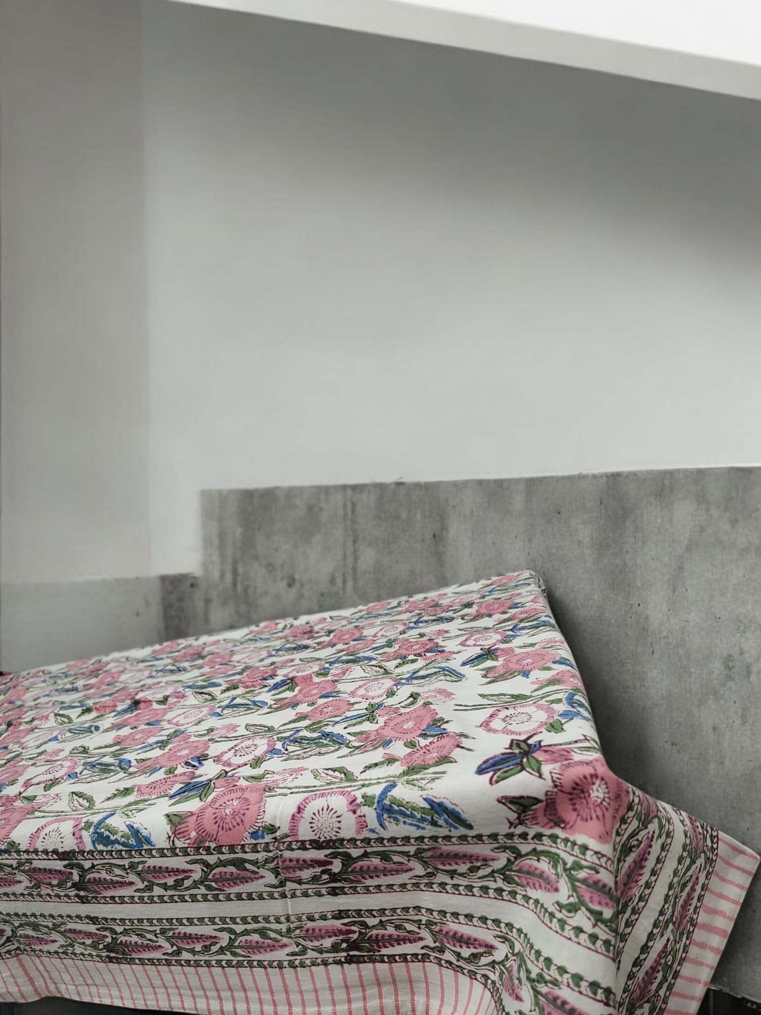 Elegant white and pink floral hand block print tablecloth draped over a table, perfect for dining and celebrations.