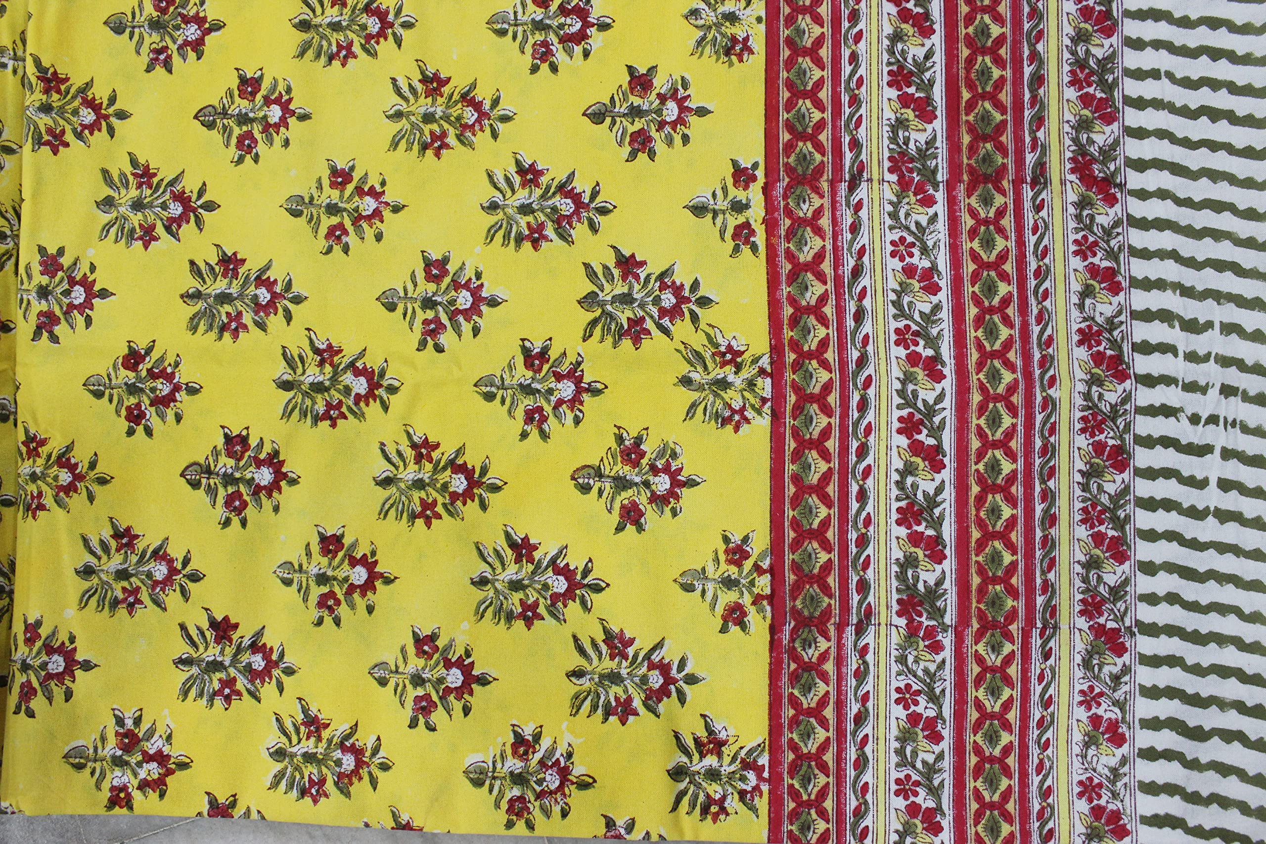 Vibrant yellow floral hand block print fabric with intricate red and green patterns, perfect for tablecloths and home decor.