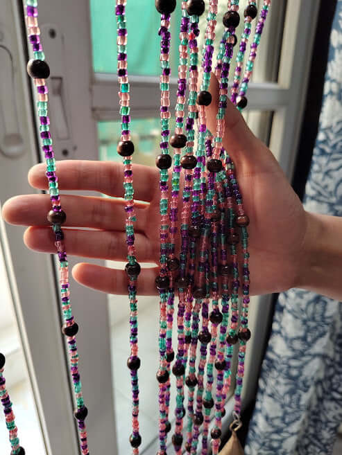 Handmade colorful glass bead strands with jingle bells—perfect for doorways or wall décor. Eco-friendly and crafted by women's artisans in India.