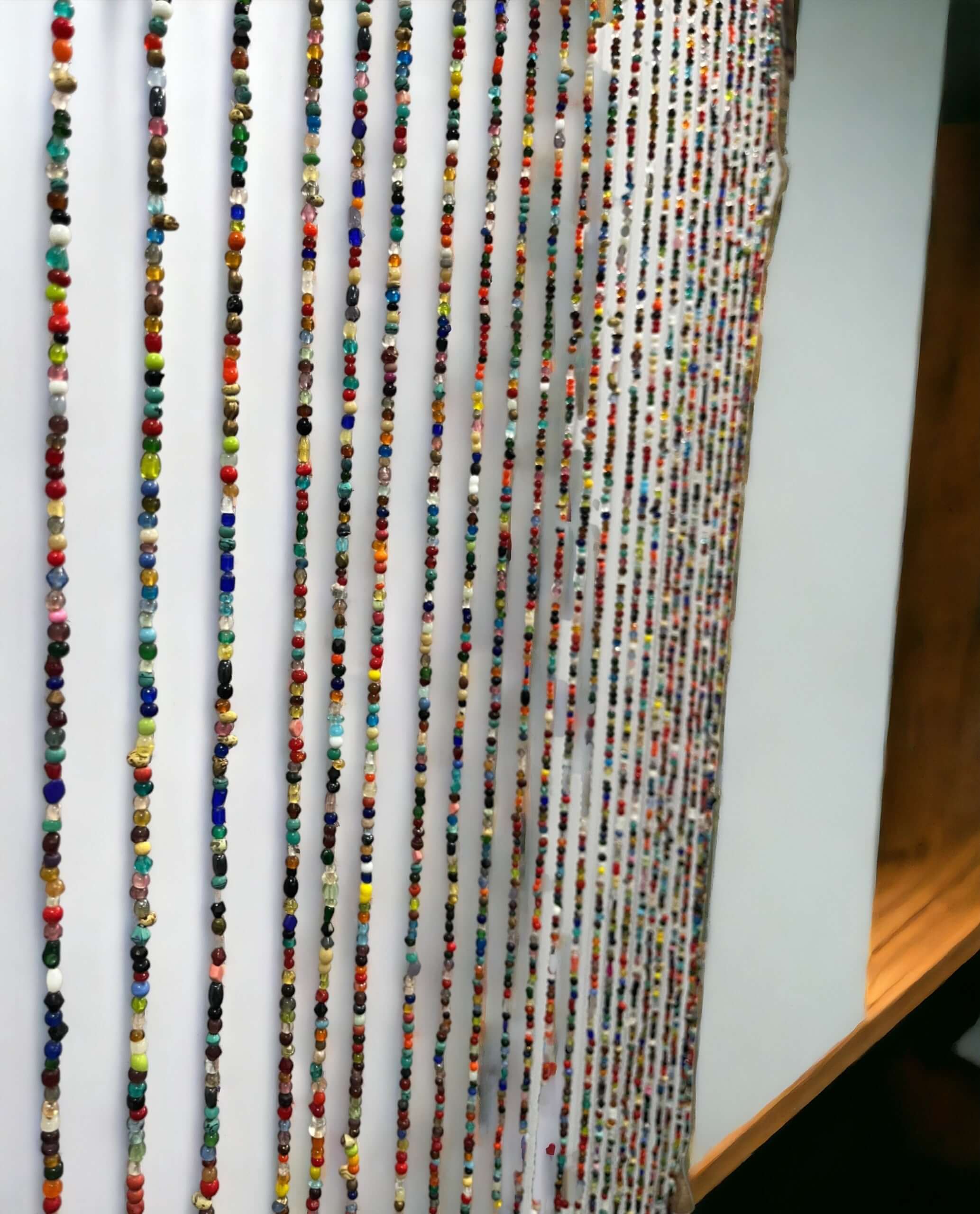 Colorful Bohemian beaded doorway garland with jingle bells, perfect for a stylish room divider.