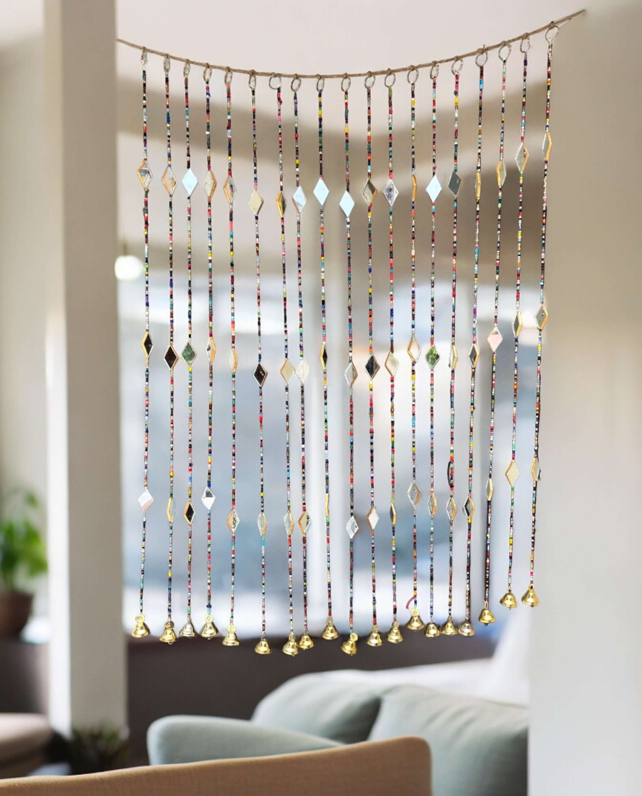 Colorful bohemian beaded curtain with glass beads and metal bells, perfect for doorways and home decor.