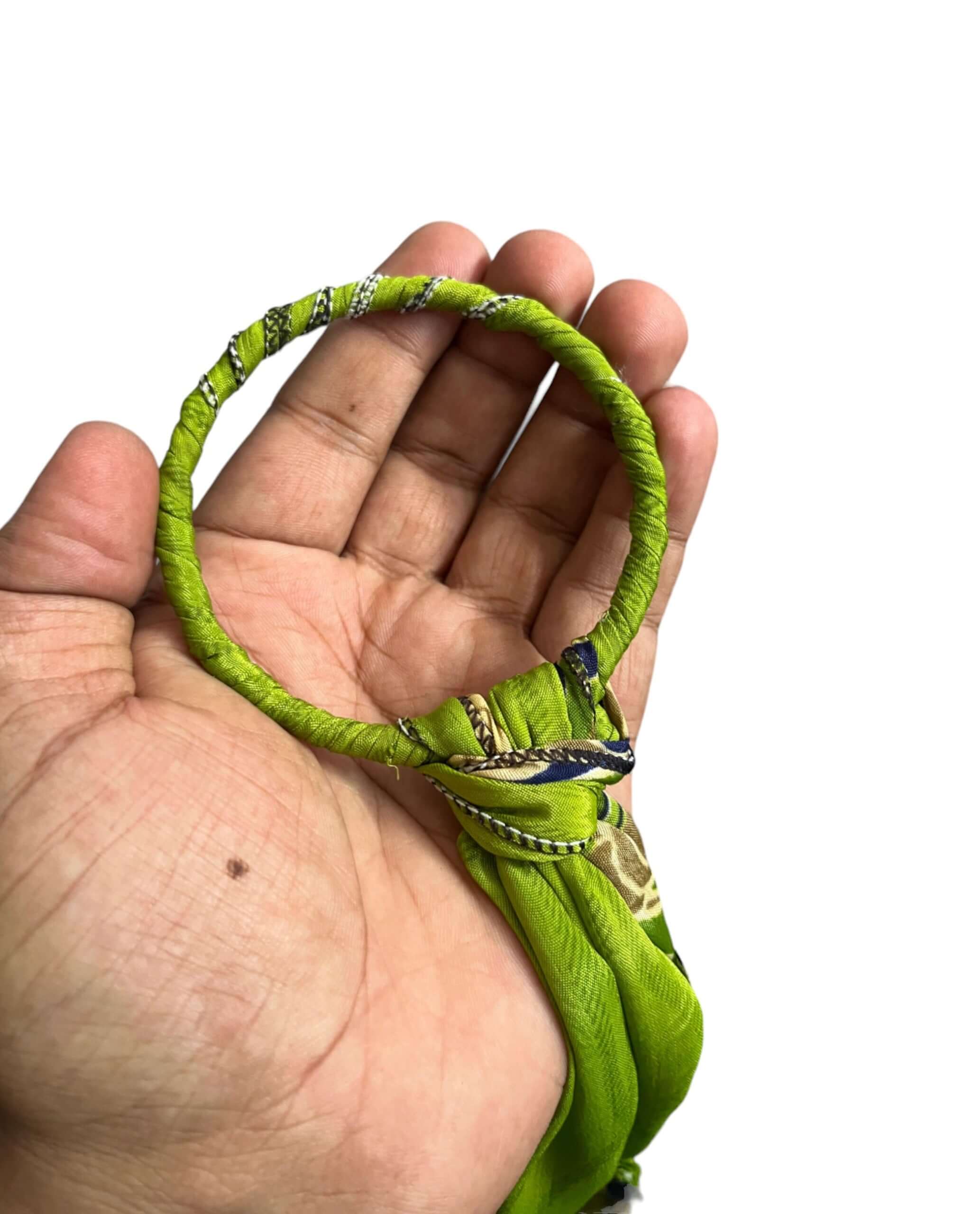 Handcrafted green metal ring adorned with colorful fabric for bohemian door hanger decoration.