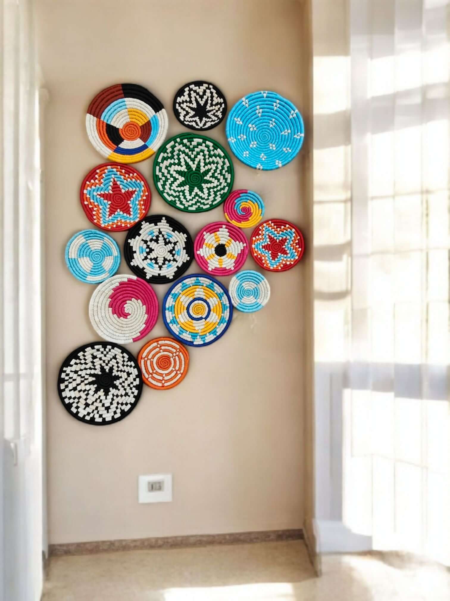 Colorful handwoven Sabai grass baskets on wall, showcasing boho decor and vintage charm for living room.