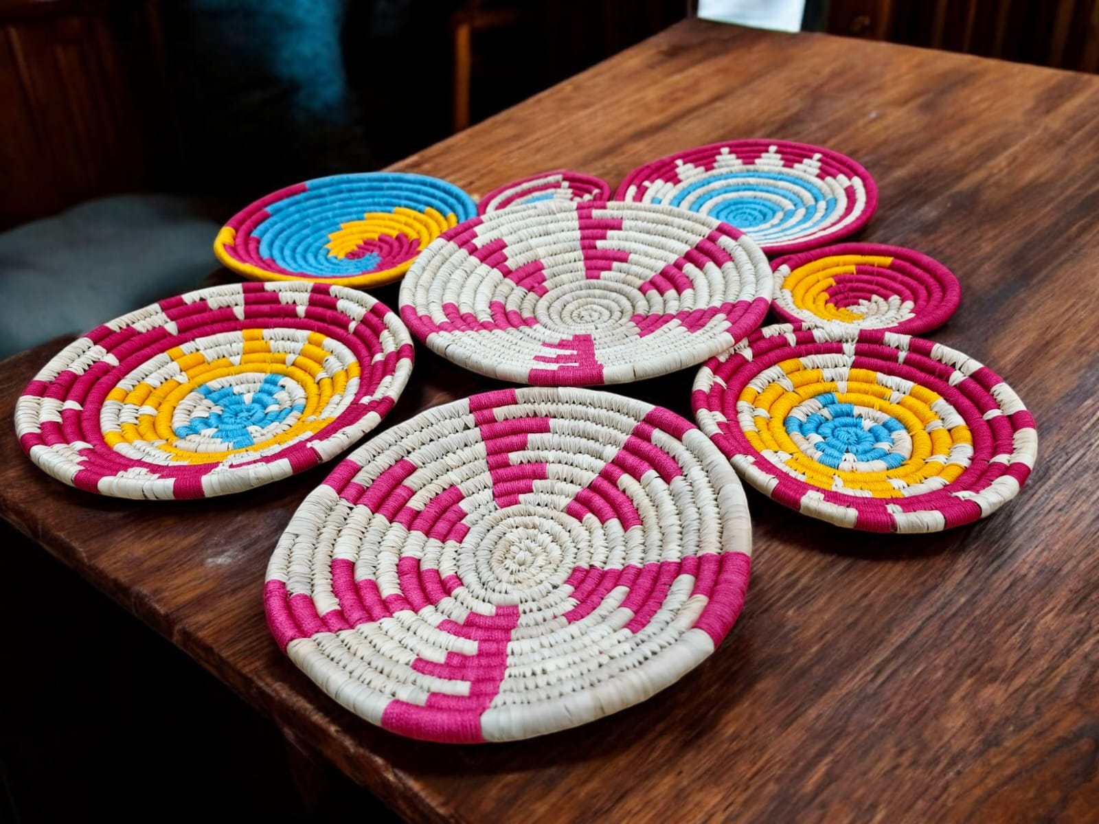Handwoven multicolor rattan wall baskets on a wooden surface, perfect for boho wall decor and natural home accents.