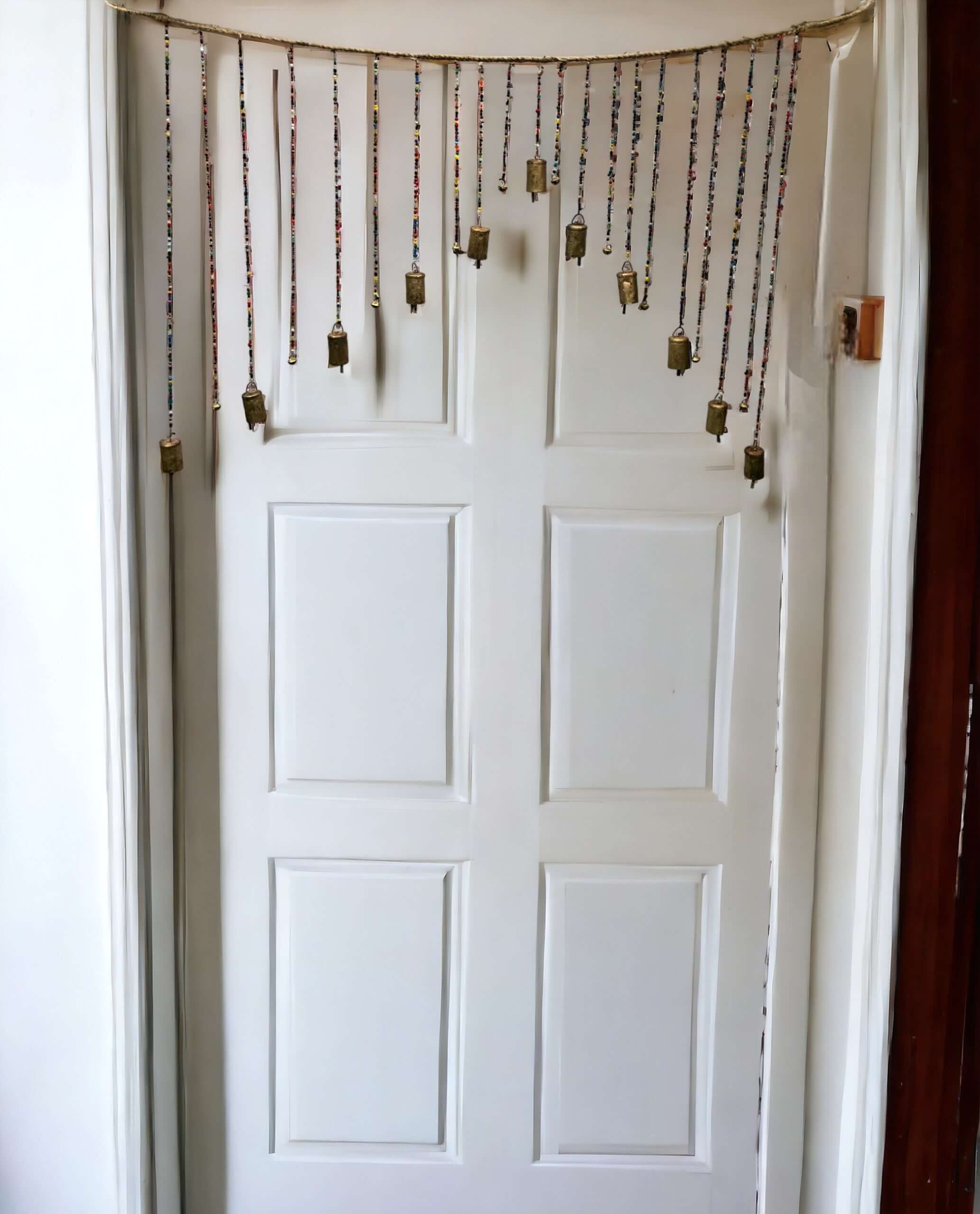 Bohemian beaded wall door hanging with multicolour glass beads and brass bells, perfect for hippie home décor.