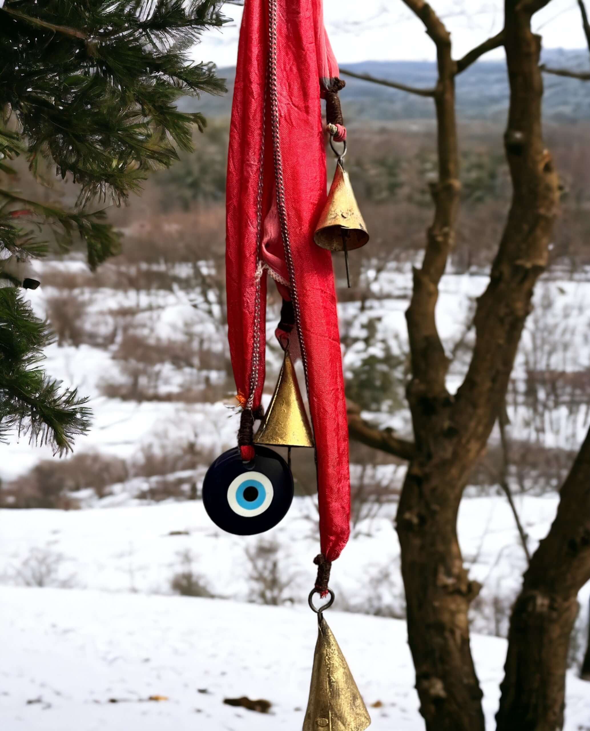 Handmade Evil Eye metal bell door hanger with vibrant sari fabric, perfect for holiday decor and bohemian accents.