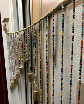 Beaded wall door hanging valance with multicolour glass beads and brass bells, bohemian style home décor.