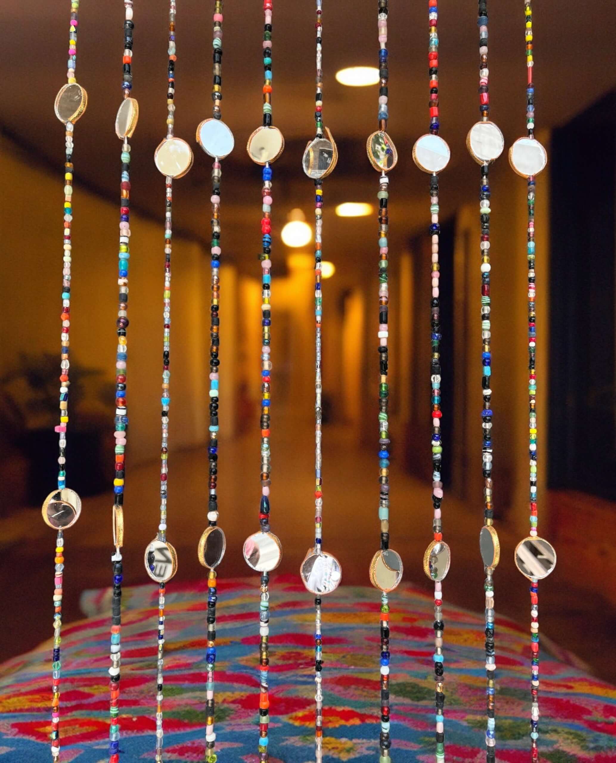 Bohemian beaded curtain with colorful glass beads and metal accents, perfect for doorway decoration or wall hanging.