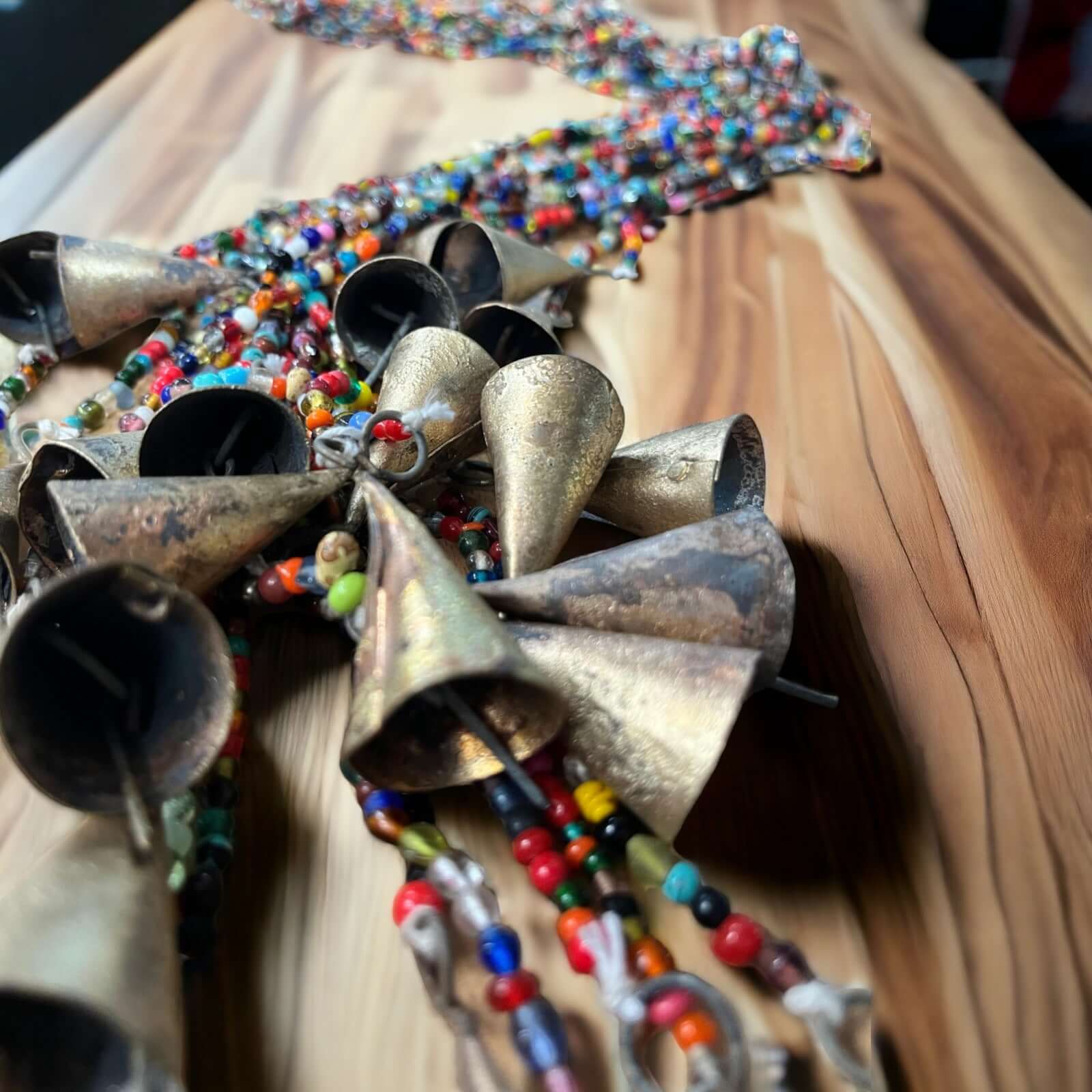 Bohemian glass beaded curtain with colorful beads and metallic bells, perfect for hippie decor.