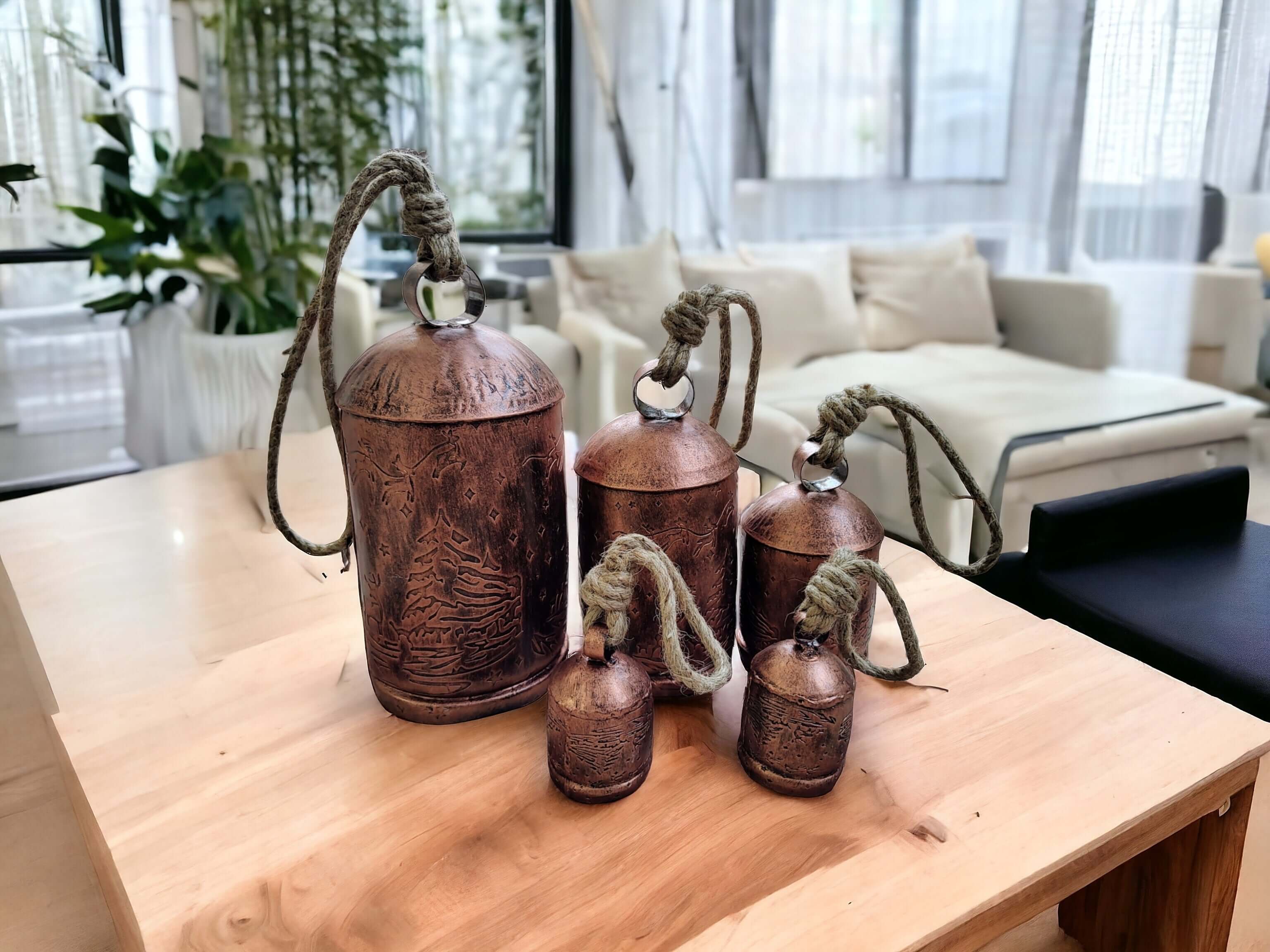 Set of 5 rustic antique cow bells with jute handles, perfect for Christmas and garden decorations.
