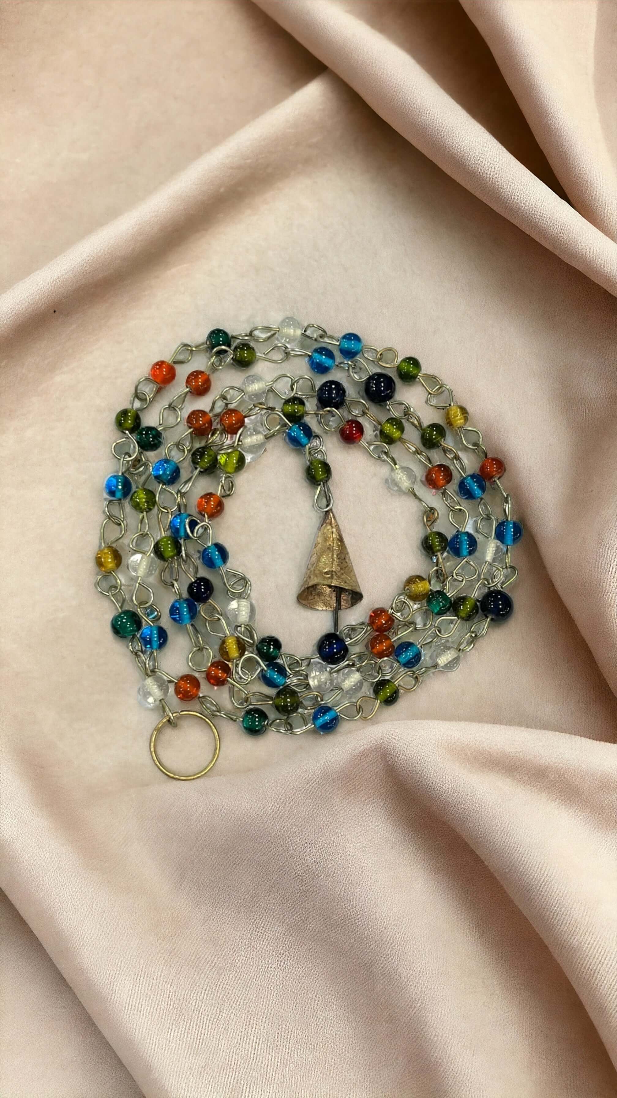 Colorful beaded curtain chain featuring jingle bells, perfect for boho hippie decor and doorway accents.