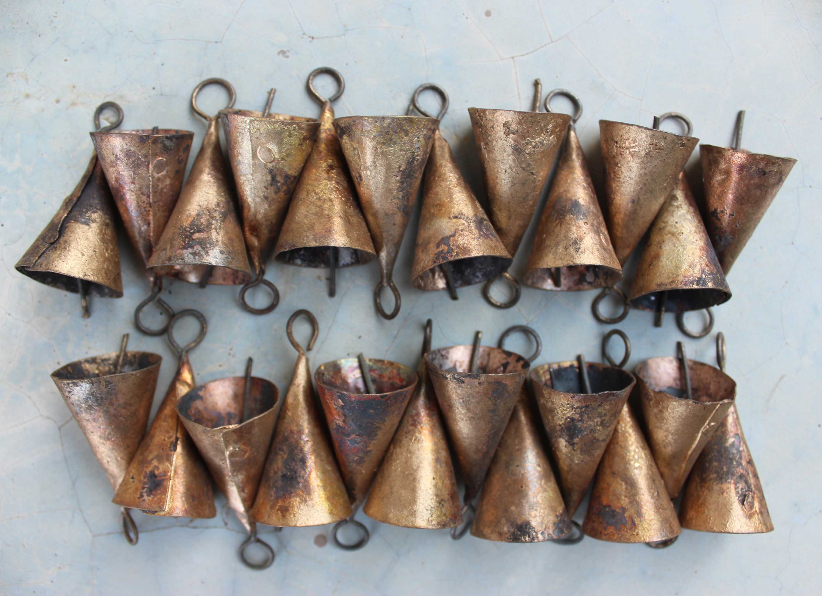 Shabby chic rustic cone shape bells made of recycled iron, showcasing a mix of golden and bronze finishes.