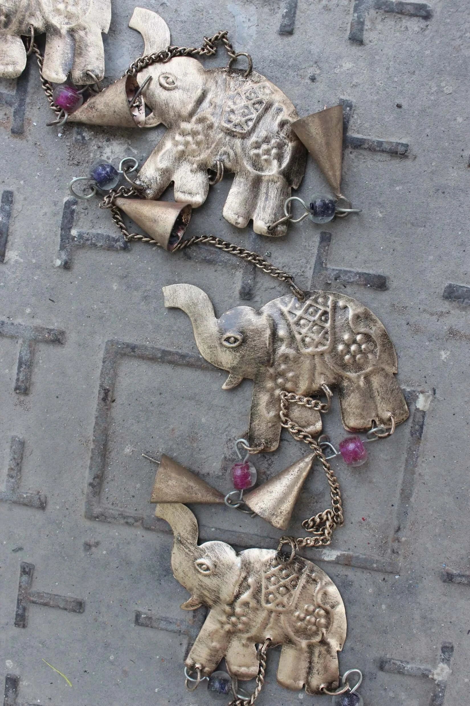 Handmade elephant wind chime wall hanging with bells, recycled iron, and glass beads, ideal for outdoor decor.