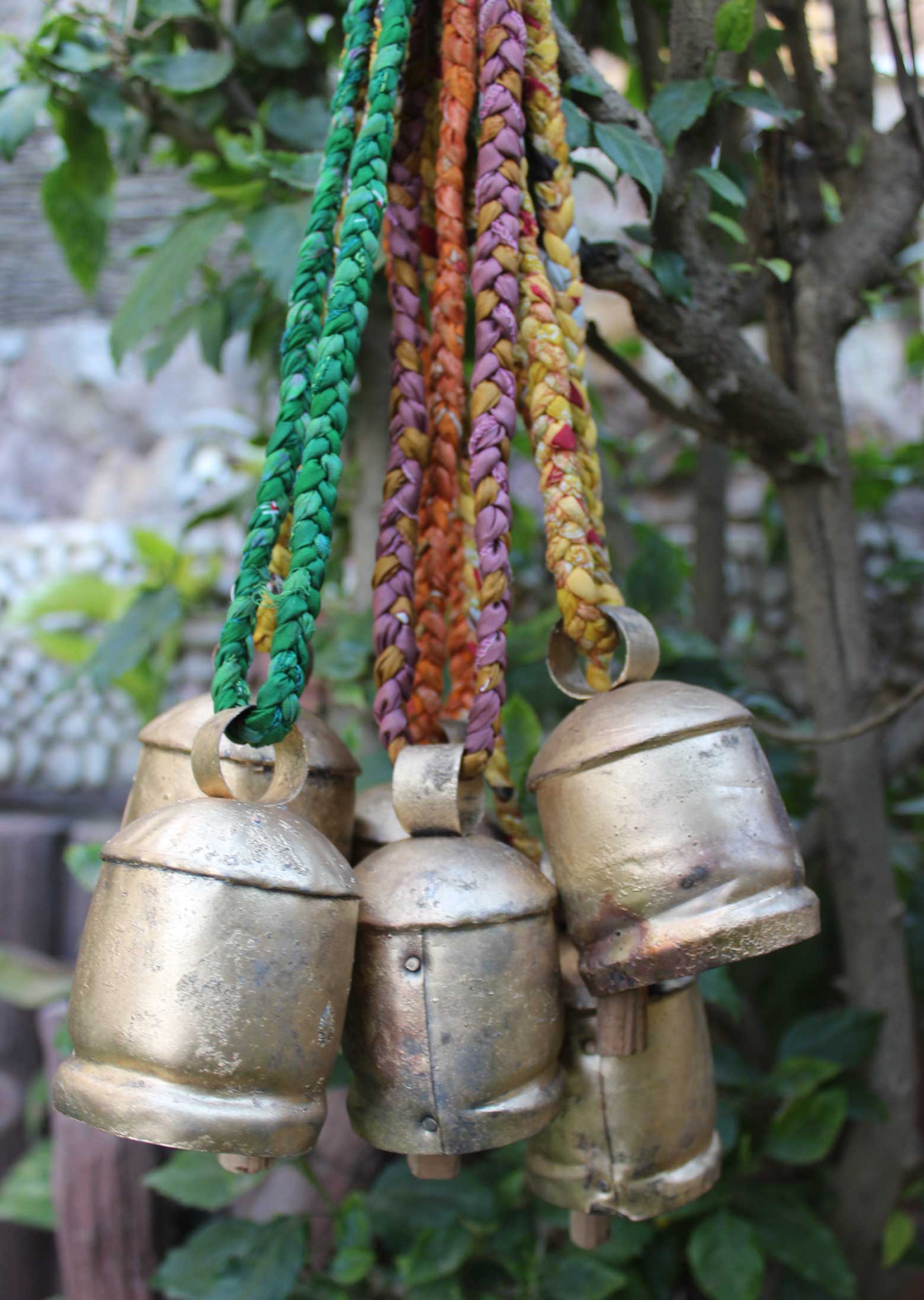Rustic vintage decorative tin cow bells set of 6 with braided sari fabric handles, perfect for garden decor.