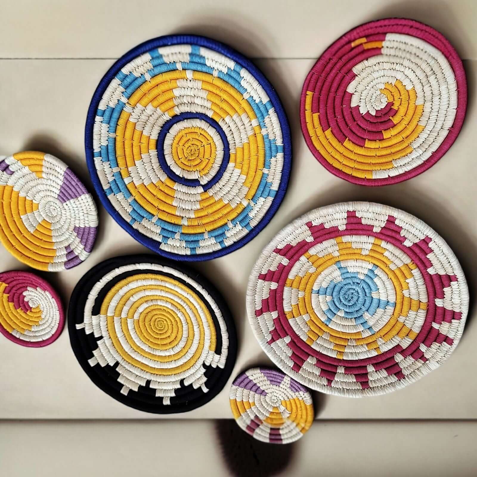 Set of 7 colorful handmade Sabai grass wall baskets, perfect for bohemian wall décor and sustainable living.