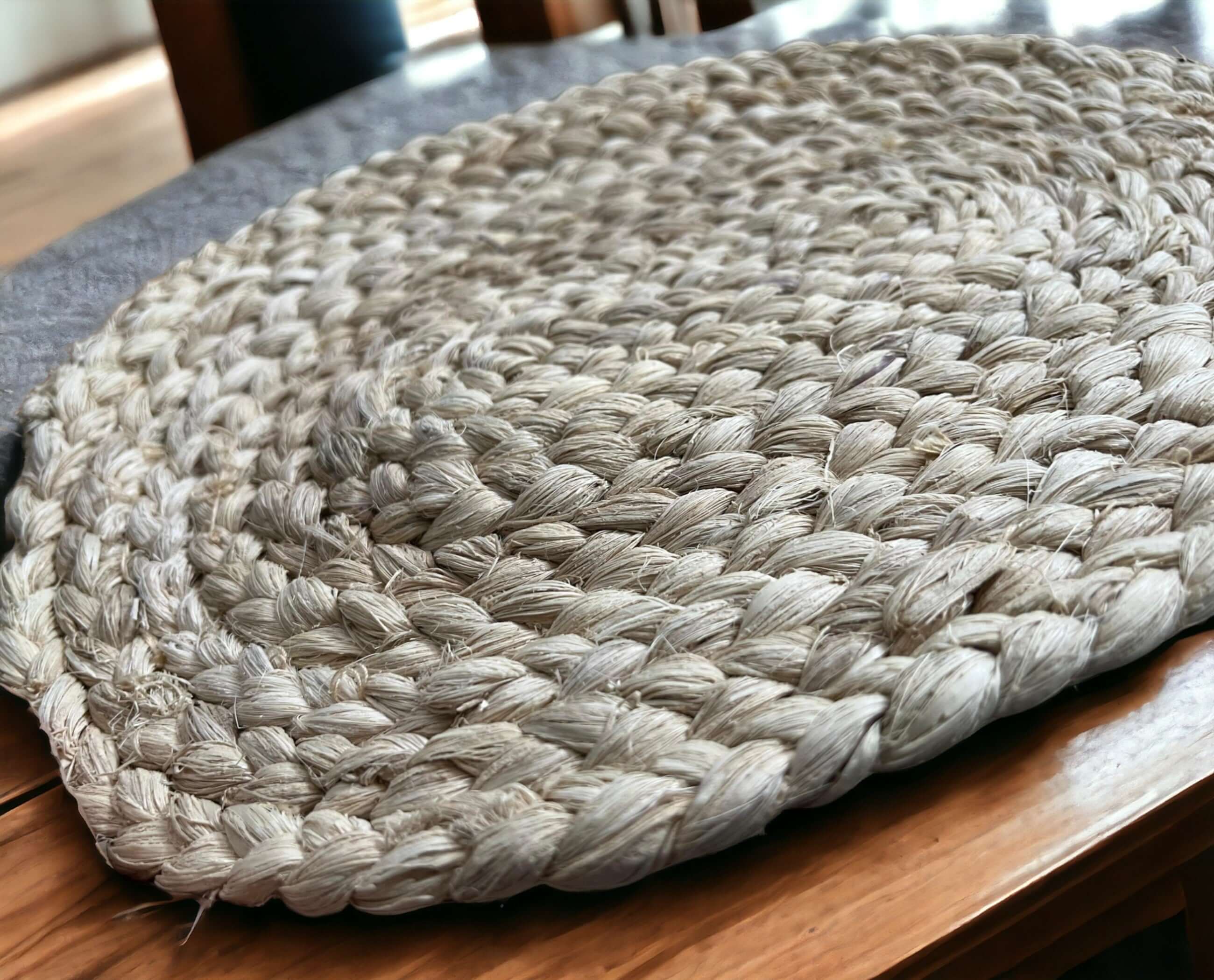Handwoven natural placemat showcasing eco-friendly materials and a stylish braided design on a wooden table.