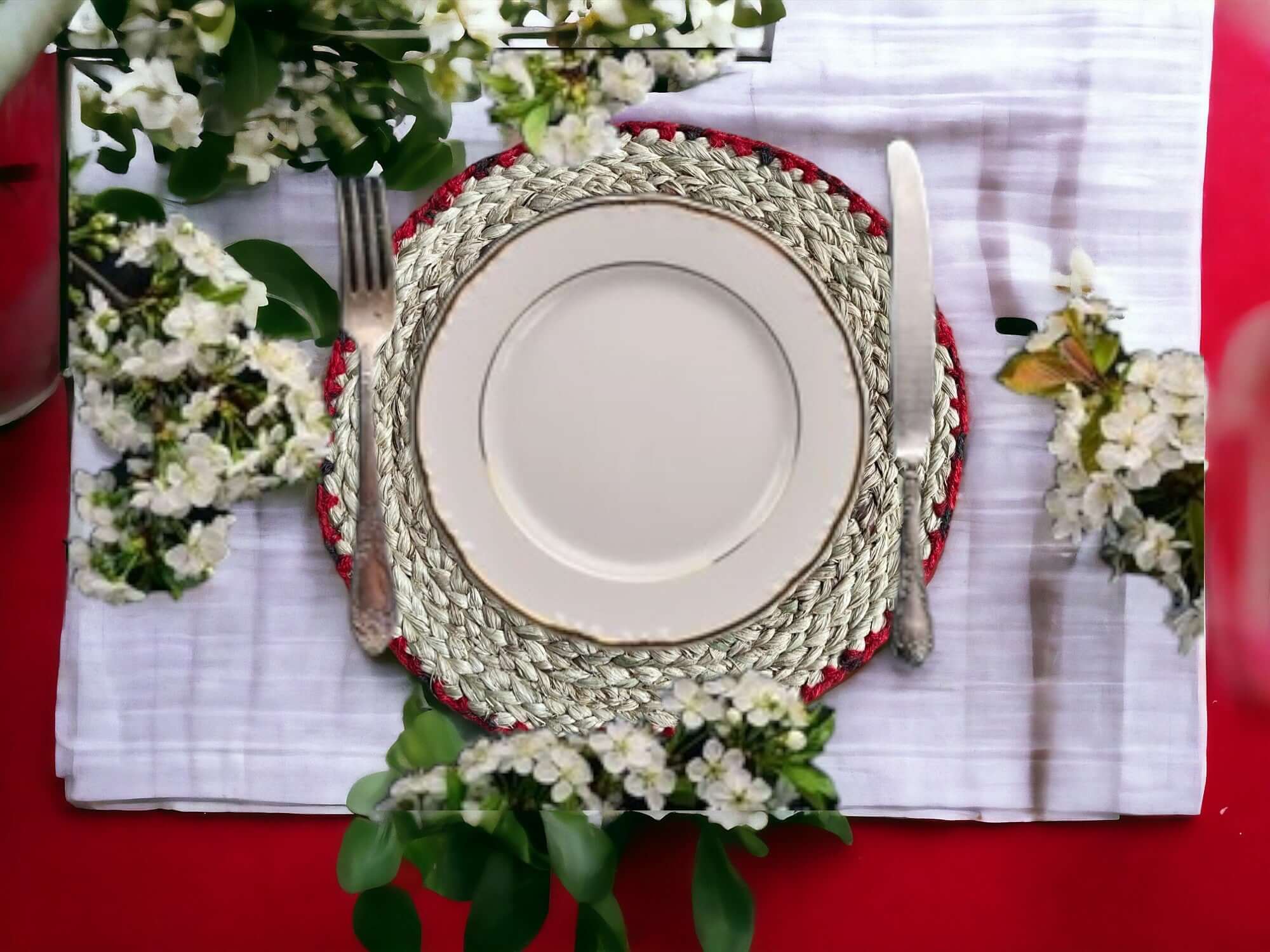 Handwoven banana fiber placemat set with a white plate on a table, adorned with flowers for an eco-friendly dining experience.