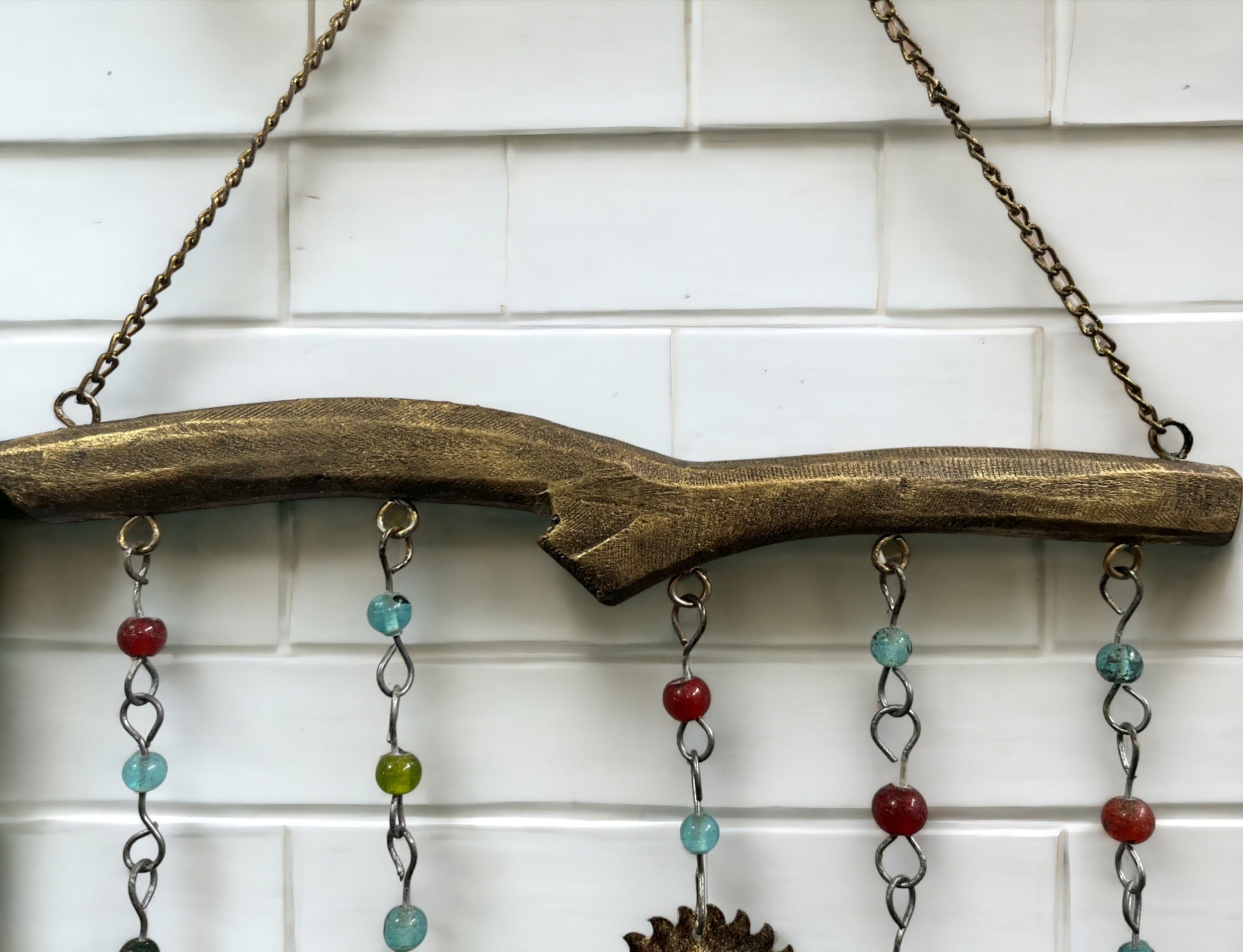 Handmade bohemian wind chime featuring colorful glass beads and decorative metal accents, perfect for home decor.