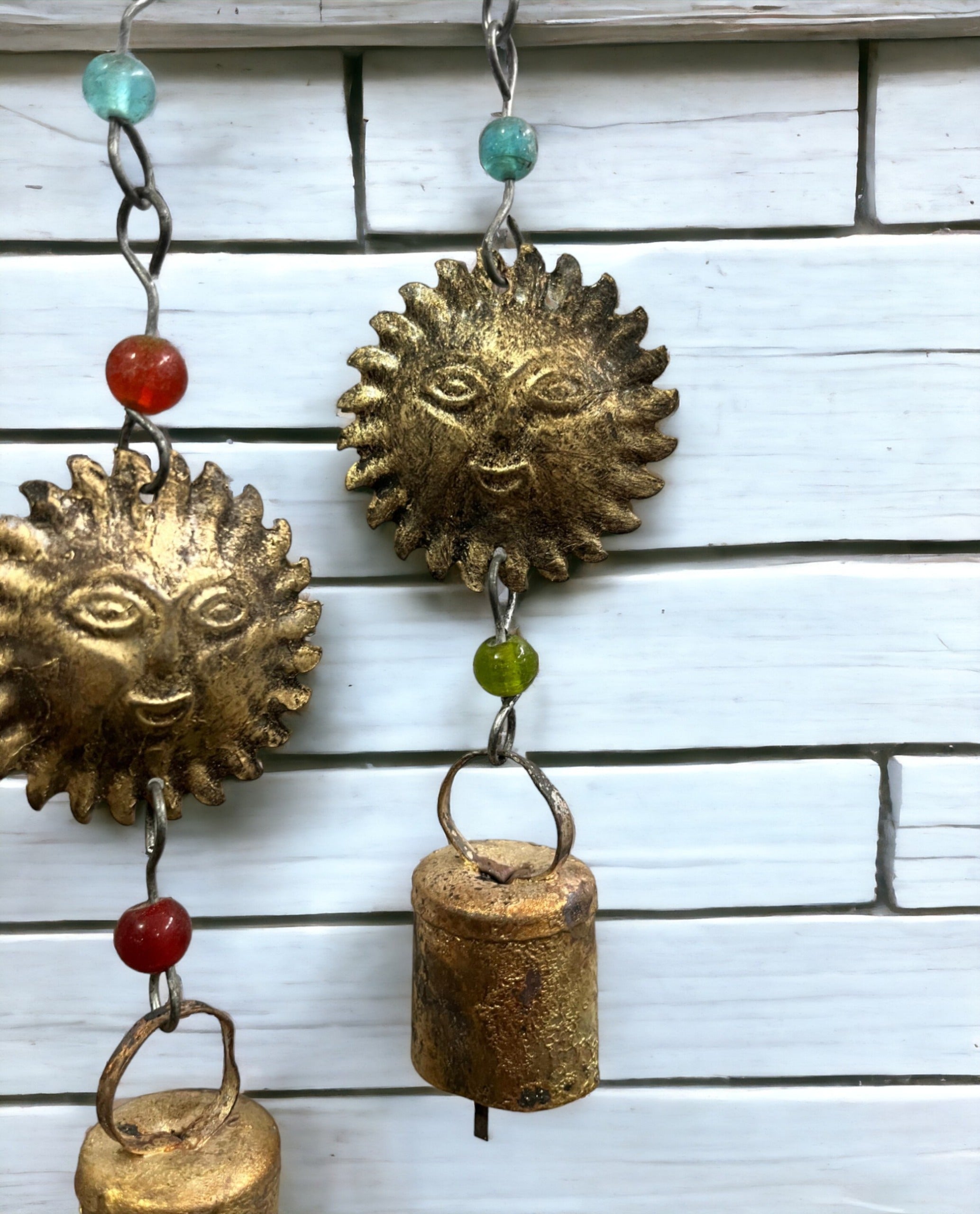 Handmade beaded iron wind chime featuring sun designs and colorful glass beads, perfect for boho décor.