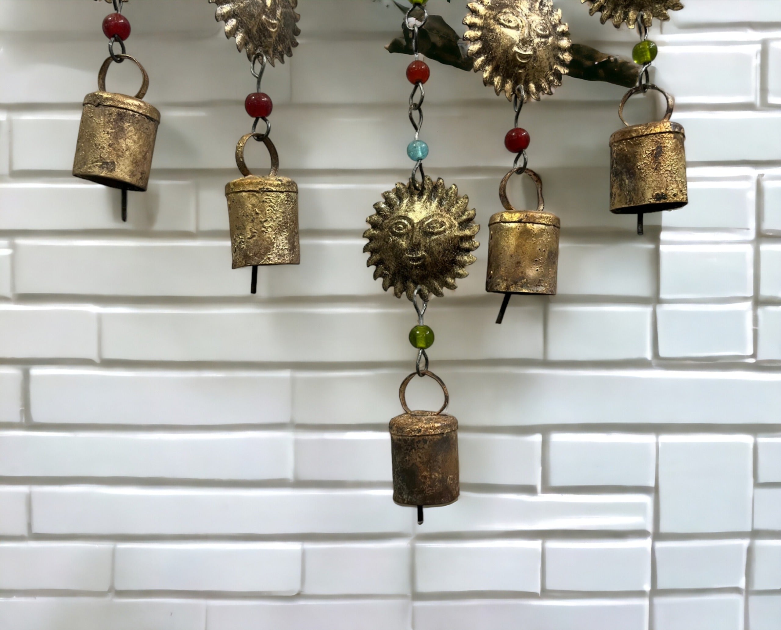 Handmade beaded iron wind chime with decorative bells featuring sun, moon, and star designs in a bohemian style.