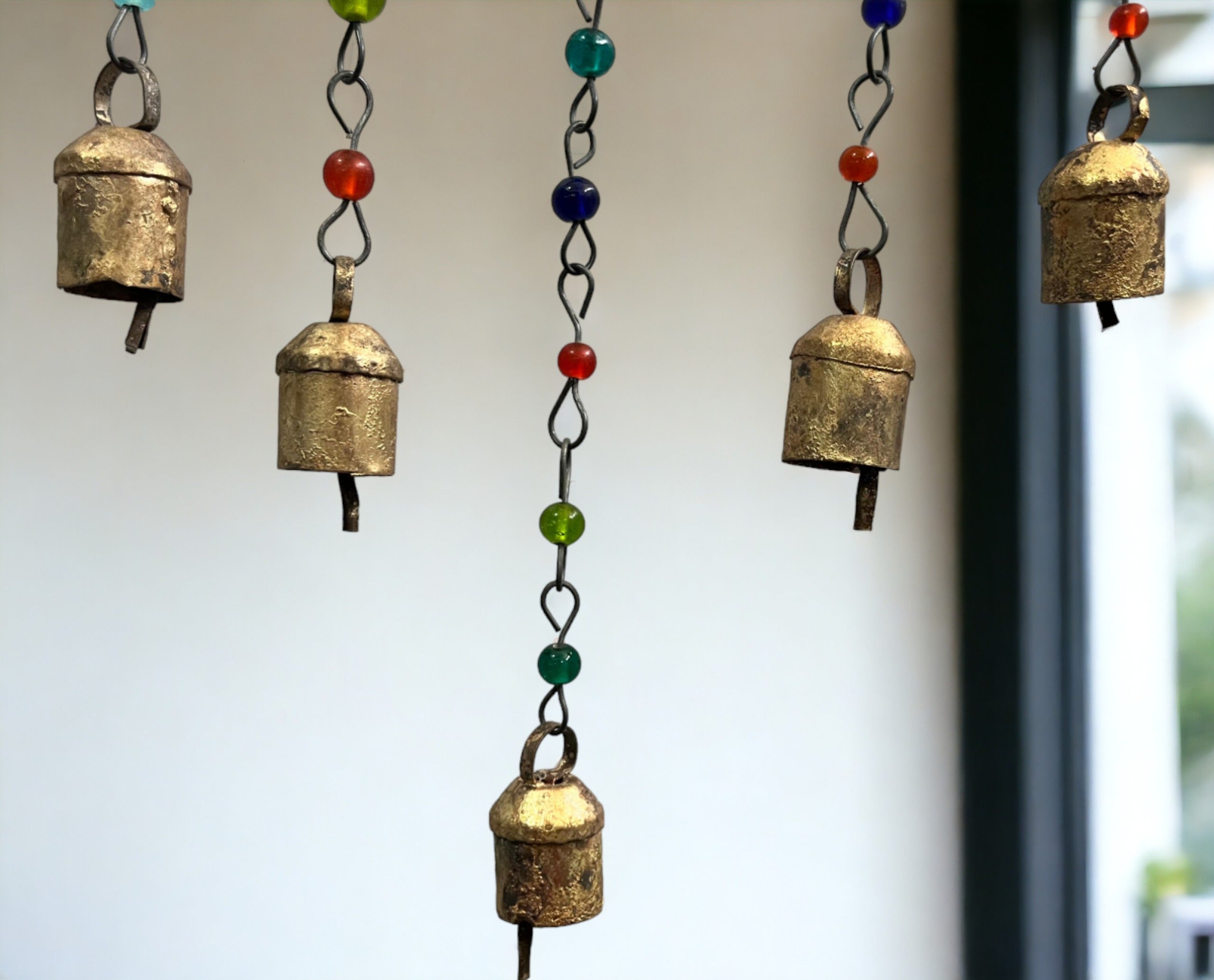 Handmade beaded iron wind chime with decorative bells in assorted colors, perfect boho decor for any occasion.