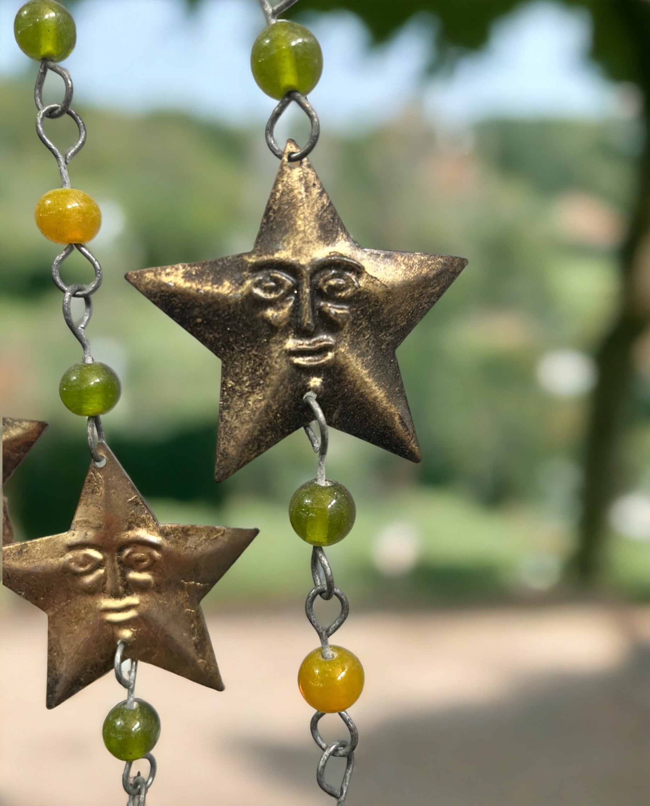 Handmade iron star wind chime with glass beads, crafted for boho decor and suncatchers.