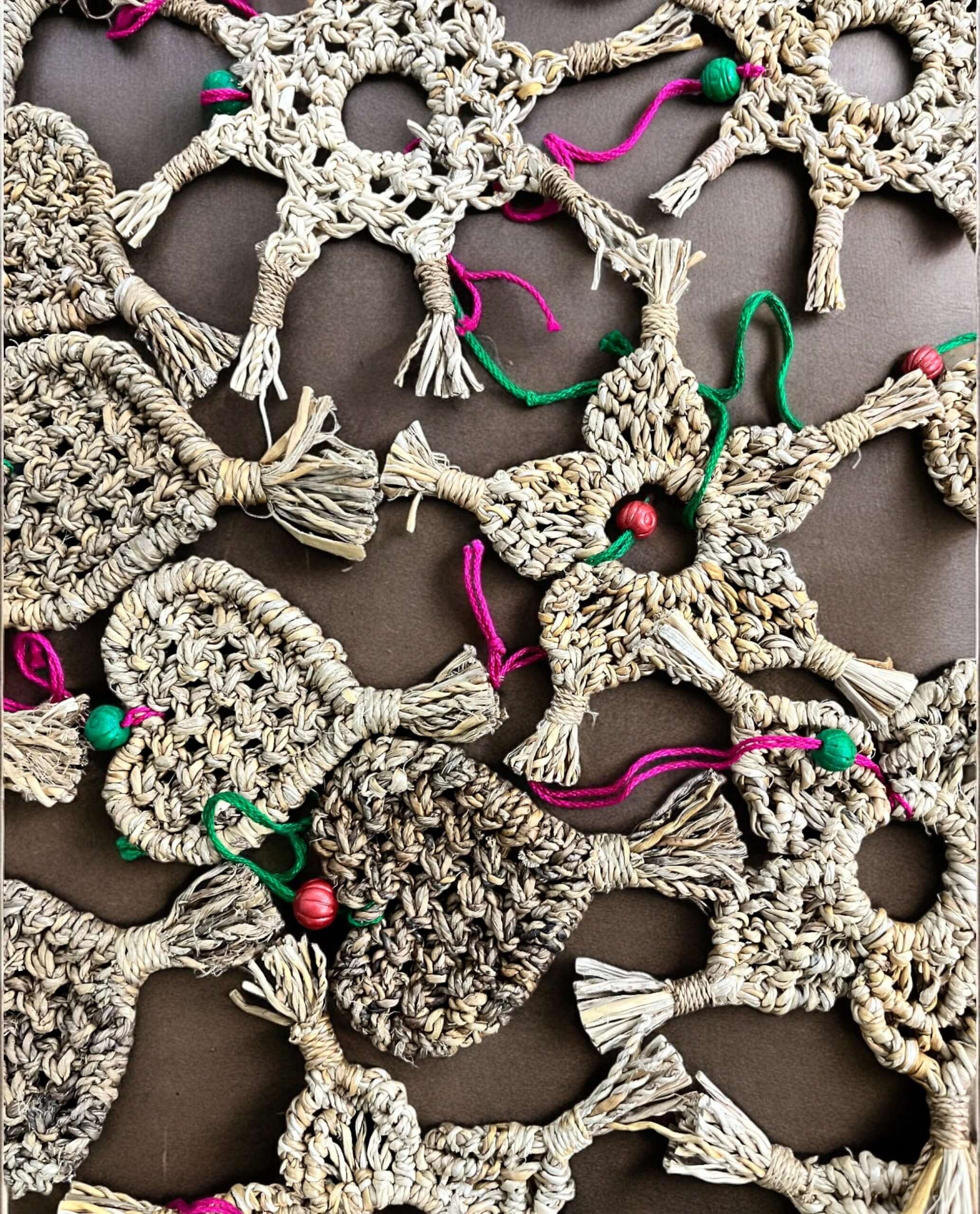 Handwoven star and heart decorations made from banana fibre grass, showcasing eco-friendly Christmas ornaments.