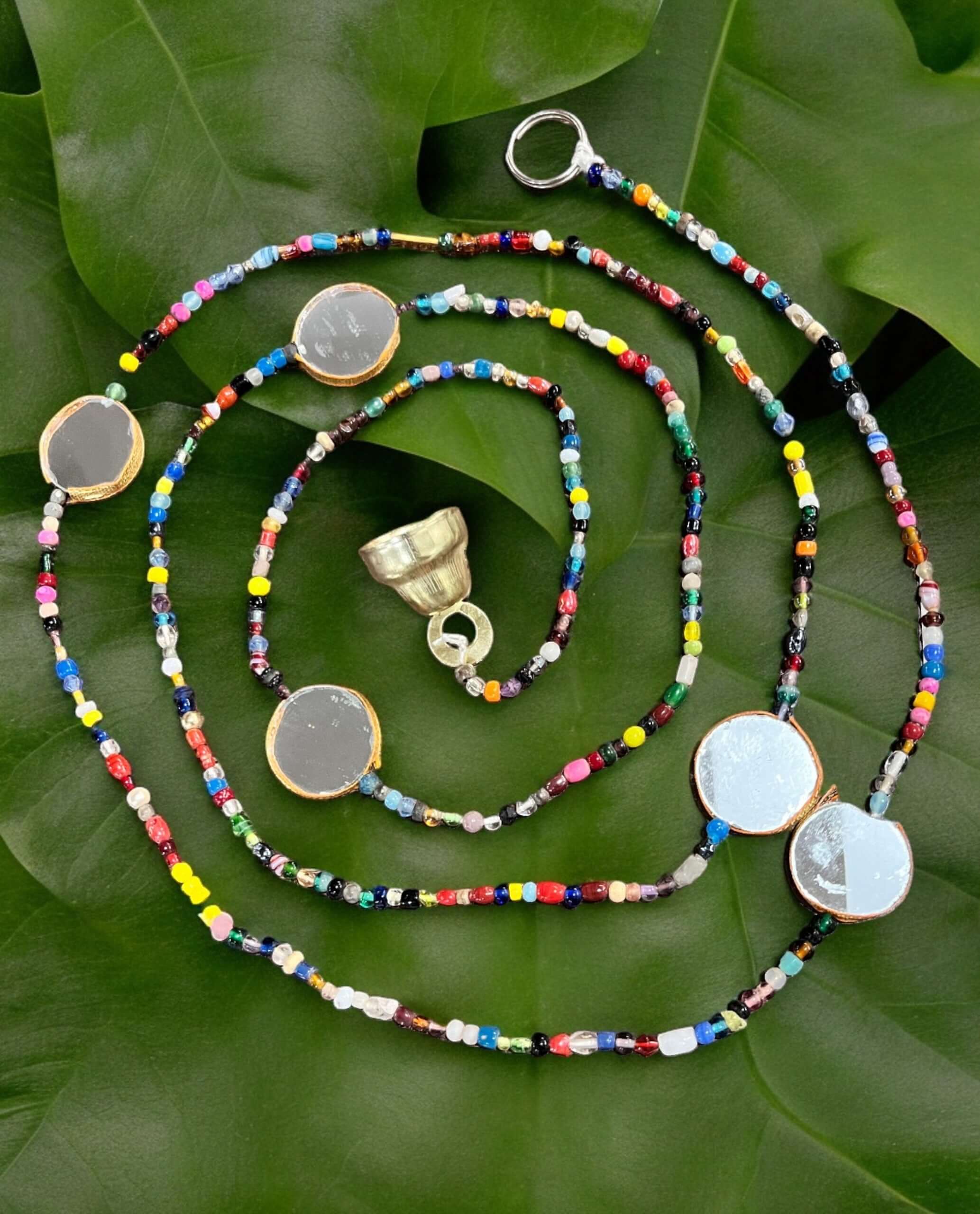 Bohemian beaded curtain with colorful glass beads and metal bells, perfect for doorway or wall decoration.