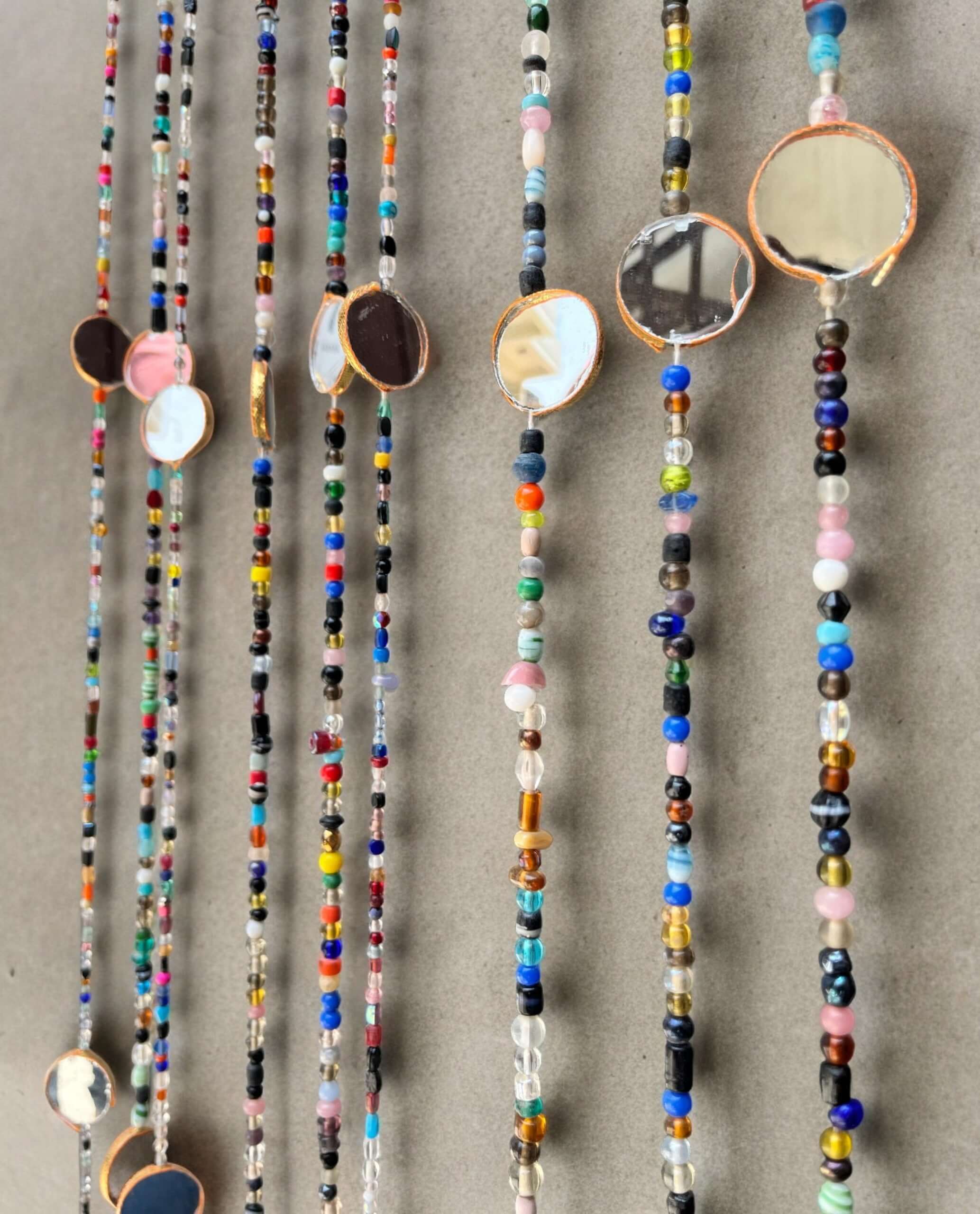 Colorful bohemian beaded curtain strands with mirrors and vibrant glass beads, perfect for hippie decor and doorway accents.