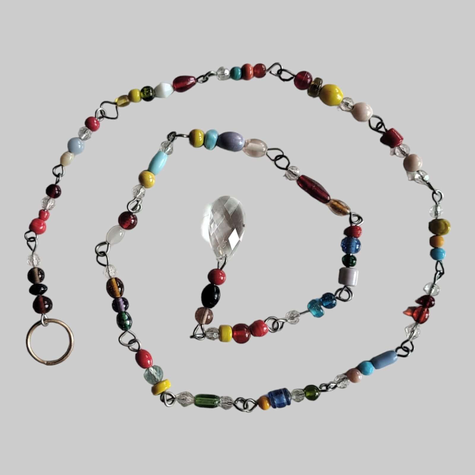 Colorful glass bead strand with crystal accent, perfect for hippie and boho-inspired beaded curtains and designs.