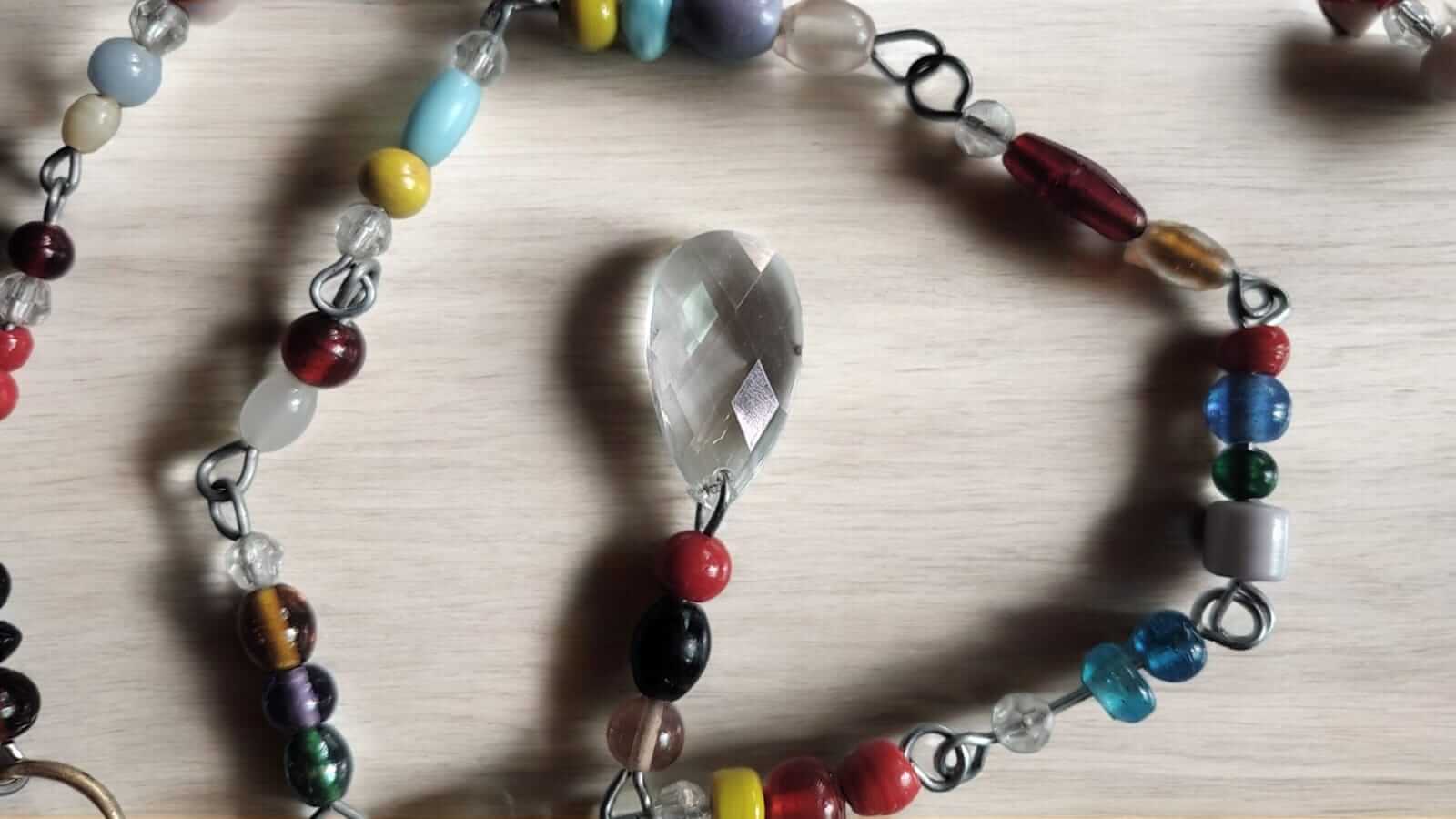 Colorful strands of glass beads with a decorative crystal pendant, perfect for hippie curtains and doorways.