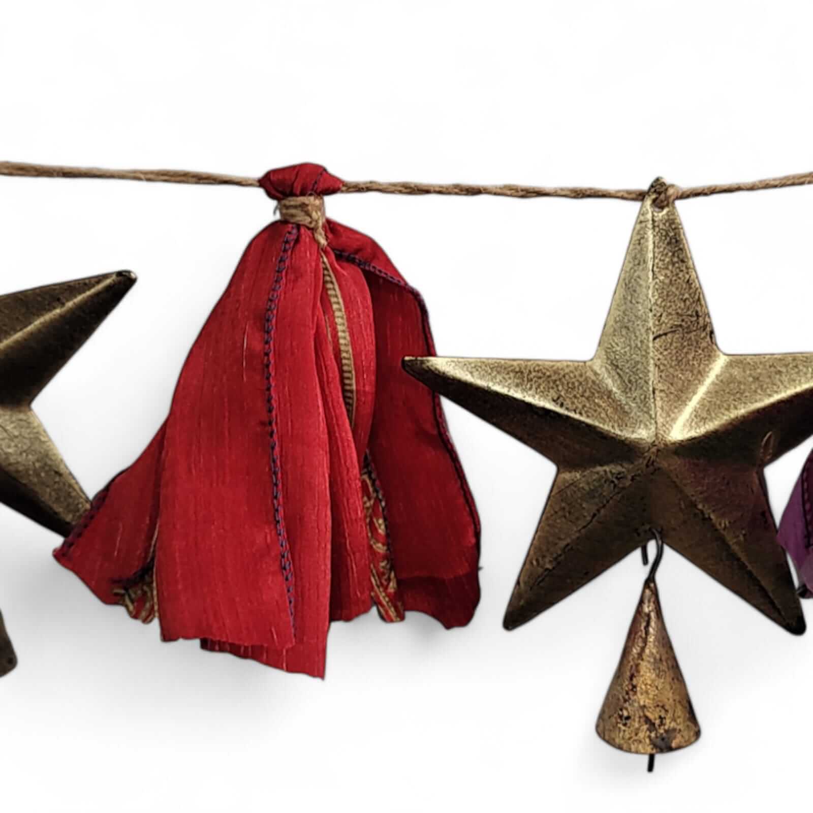 Handmade upcycled silk sari garland with metal stars and bells, featuring vibrant colors and bohemian style décor.