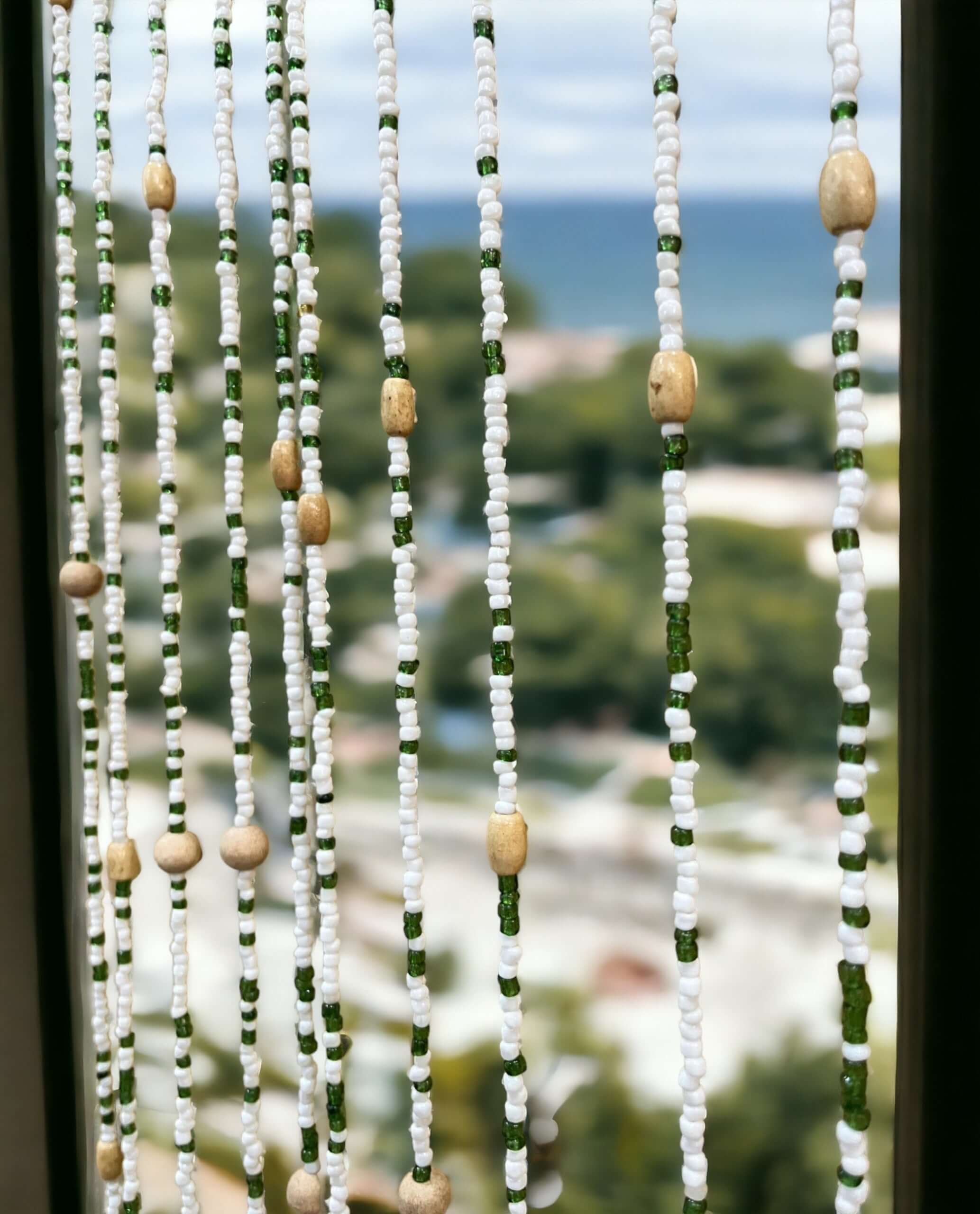 Handmade colorful glass bead strands with jingle bells—perfect for doorways or wall décor. Eco-friendly and crafted by women's artisans in India.