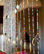 Colorful bohemian beaded curtain with glass beads and mirrors, perfect for doorways and home decoration.