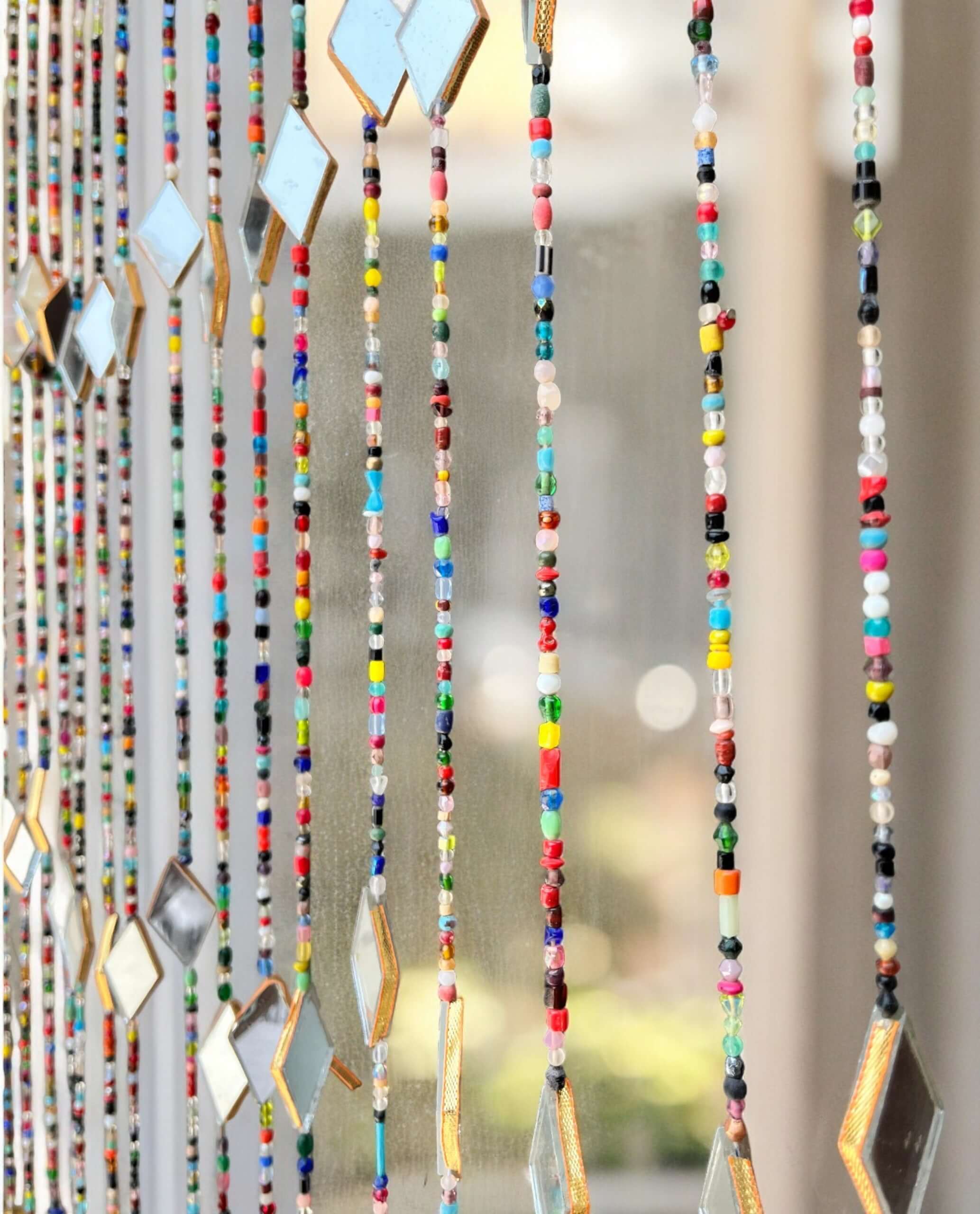 Colorful beaded curtain with glass beads and metal accents, perfect for hippie home decor and doorway decoration.