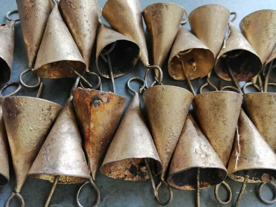 Shabby chic recycled iron cone-shaped bells, 1.75 inches tall, handmade in India, with a rustic brass finish.