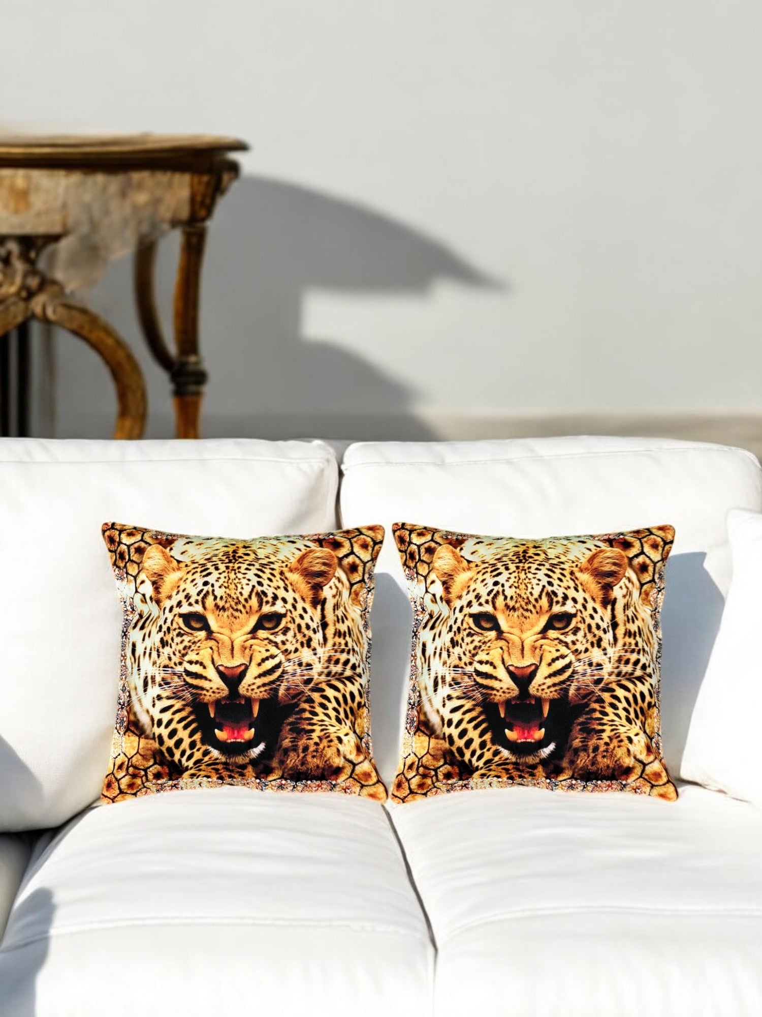 Set of 2 multicolor leopard face cushion covers on a white sofa, adding a wild touch to home decor.