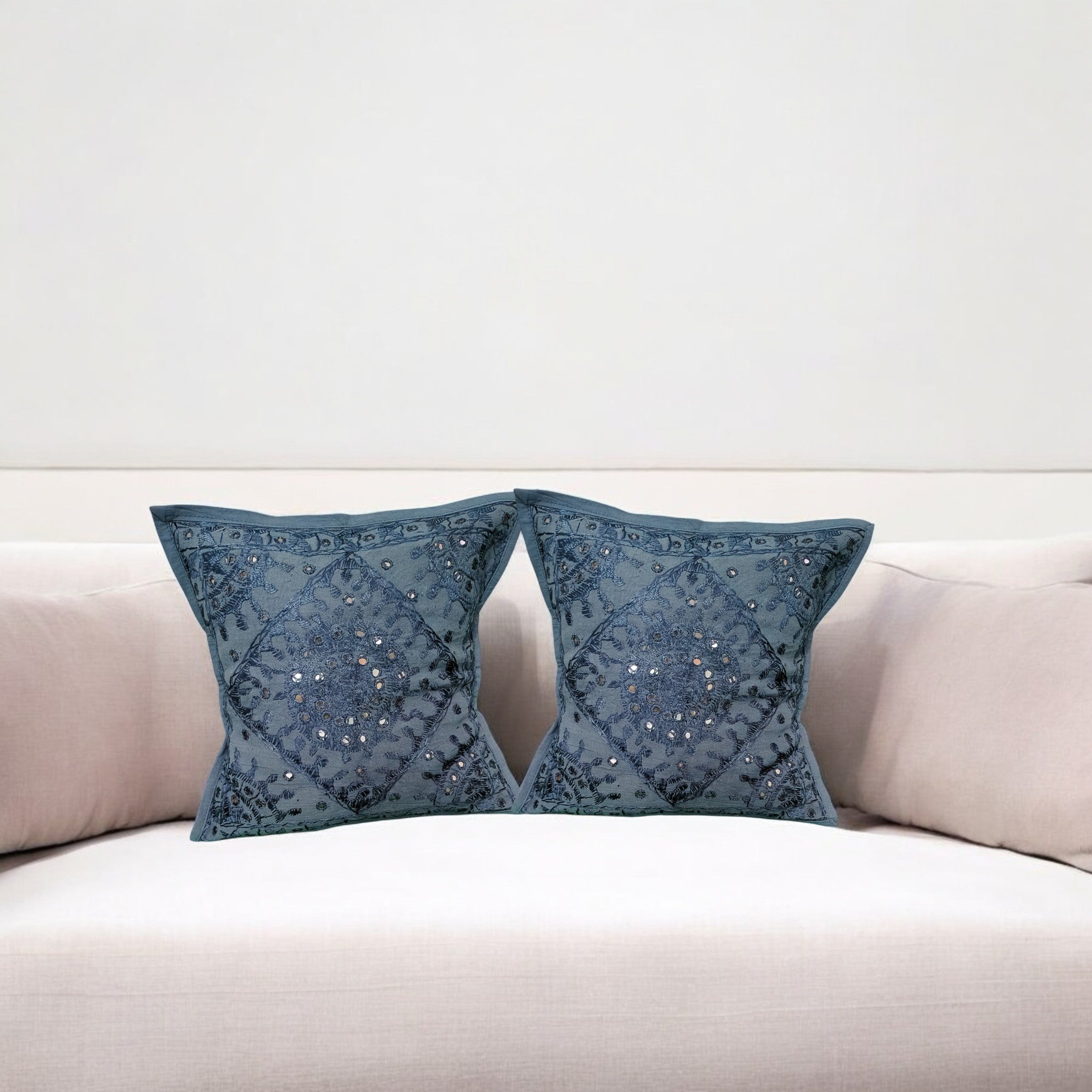 Set of 2 dark blue mirror work cotton throw pillow covers on a sofa, perfect for home decor.