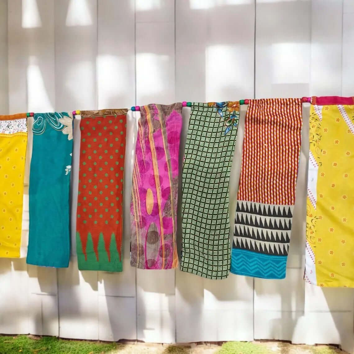 Colorful vintage sari garland hanging as home decor, showcasing unique patterns and handmade authenticity.