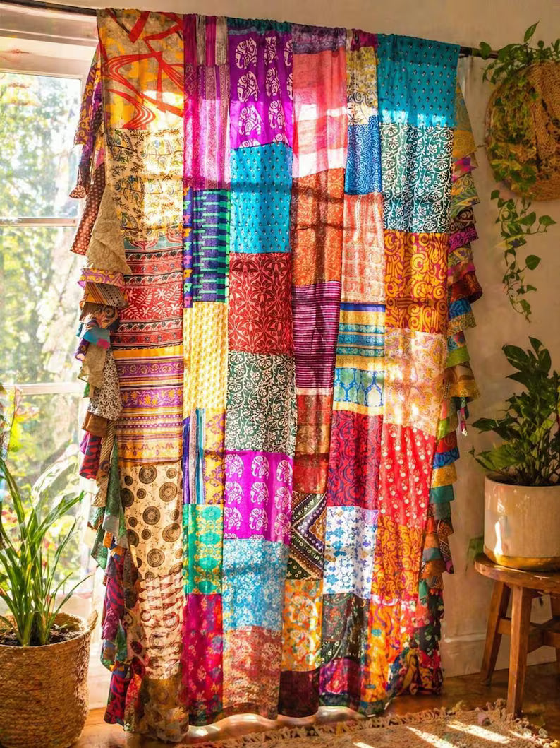 Boho sheer light filtering curtains in multicolor patchwork design, silk sari fabric, displayed in a sunny room.