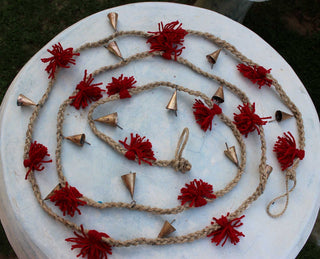 Vintage cow bells and jute garland with wool tassels, ideal for garden and party decorations