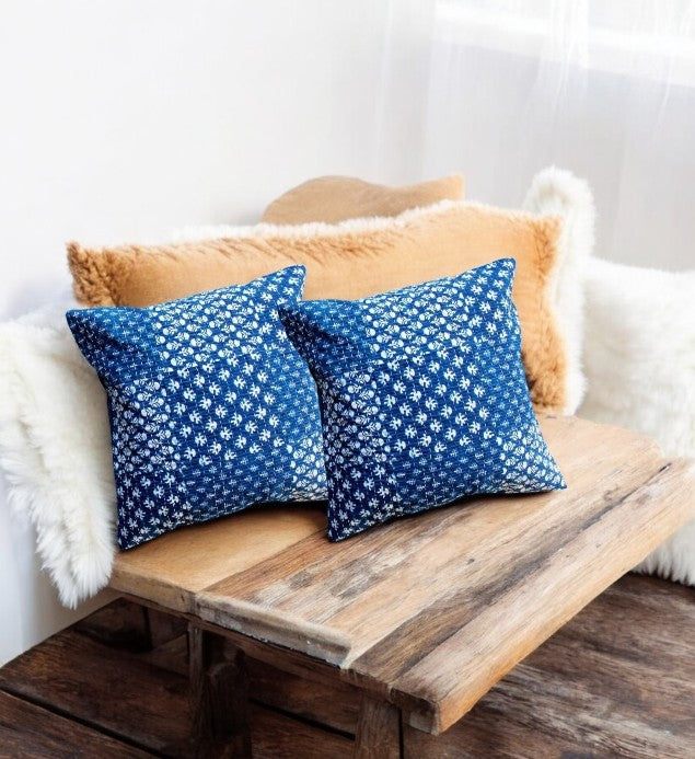 Set of 2 indigo blue geometric throw pillows on a wooden bench, ideal decorative accents for sofas and beds.