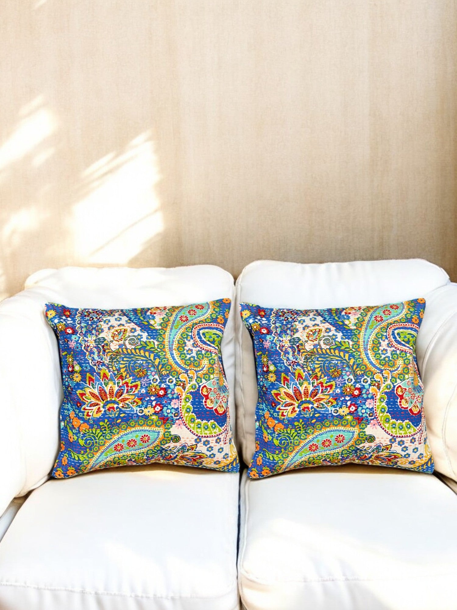 Vibrant multicolor floral paisley cushion covers on a white sofa, perfect for home decor accents.