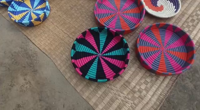 Colorful handwoven Sabai grass wall plates featuring vibrant patterns, perfect for boho wall decor.