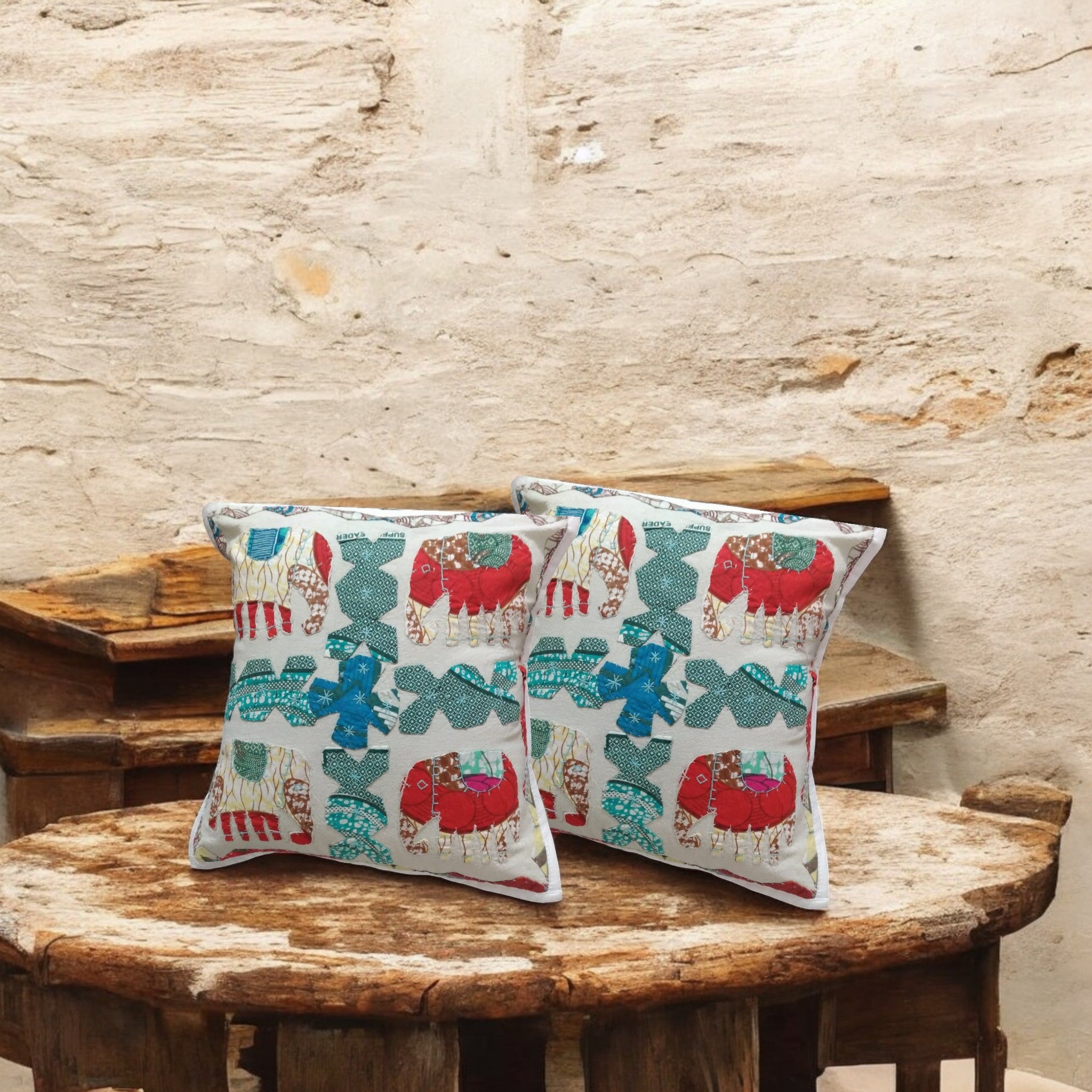 Set of 2 vibrant decorative elephant throw pillow covers on a rustic wooden table.