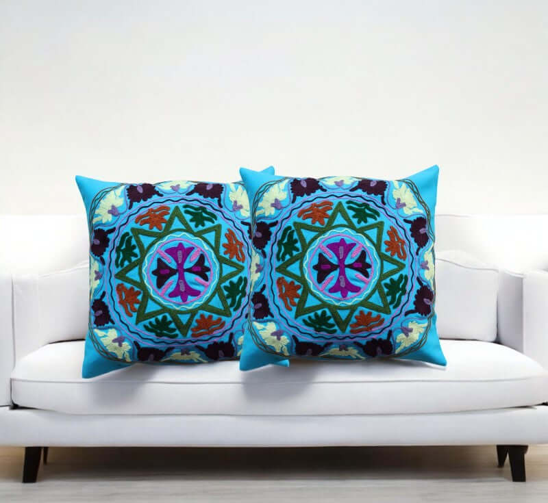 Peacock Floral Cushion Covers Set of 2 displayed on a white sofa, showcasing vibrant colors and intricate design.