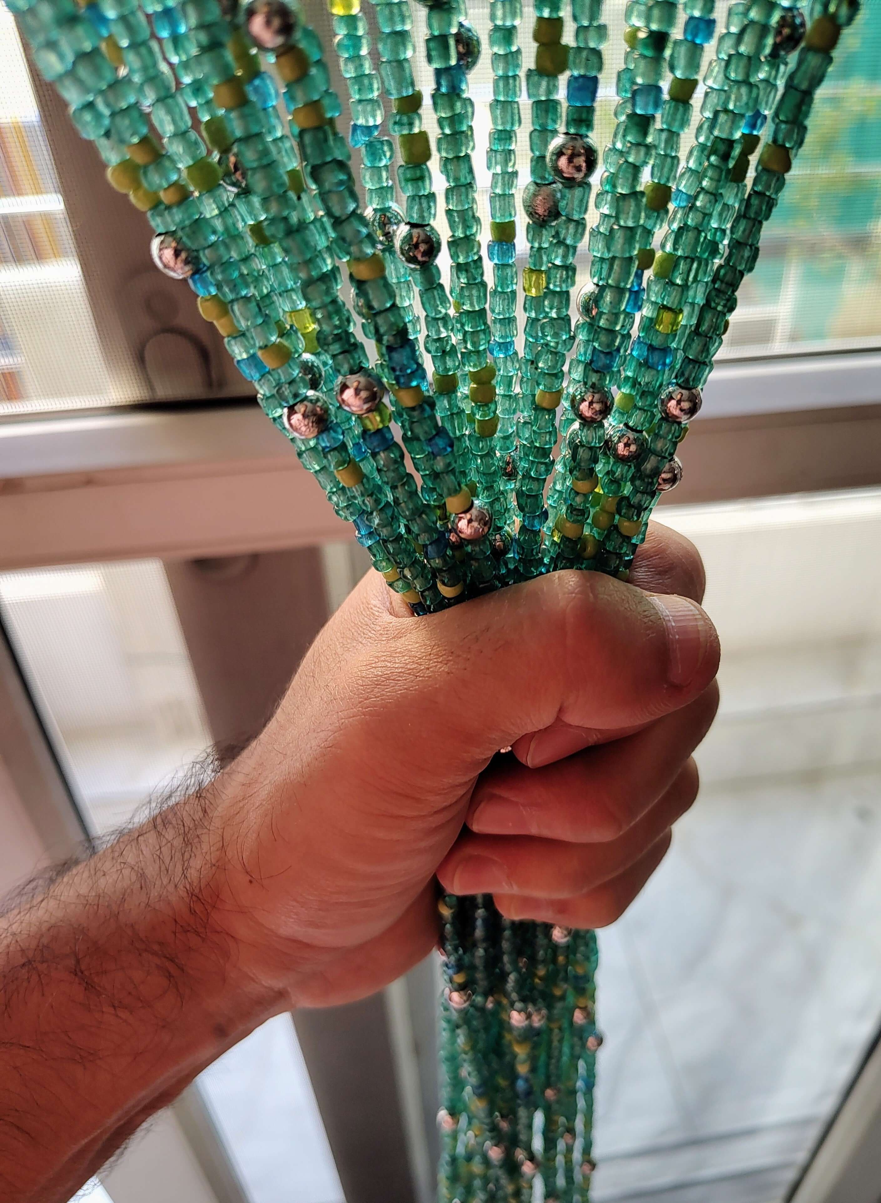 Handmade colorful glass bead strands with jingle bells—perfect for doorways or wall décor. Eco-friendly and crafted by women's artisans in India.